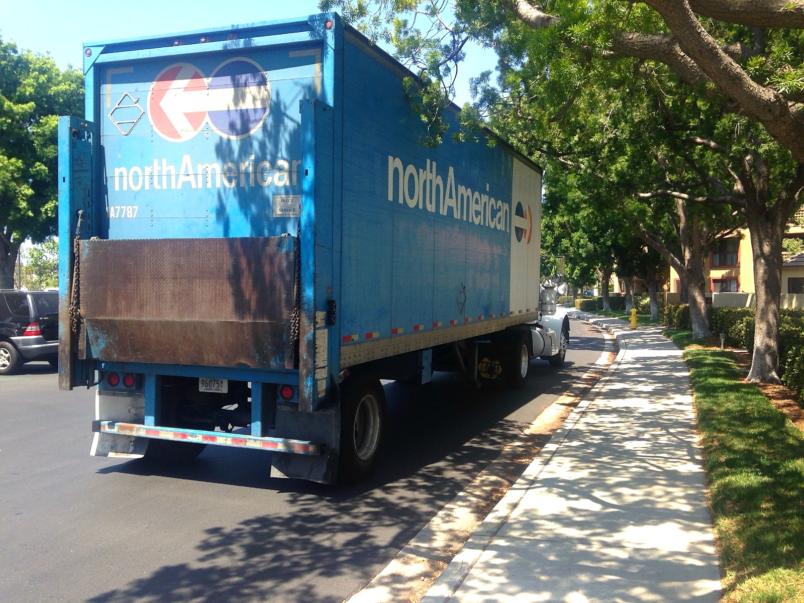 A North American removals truck parked in a quiet residential street