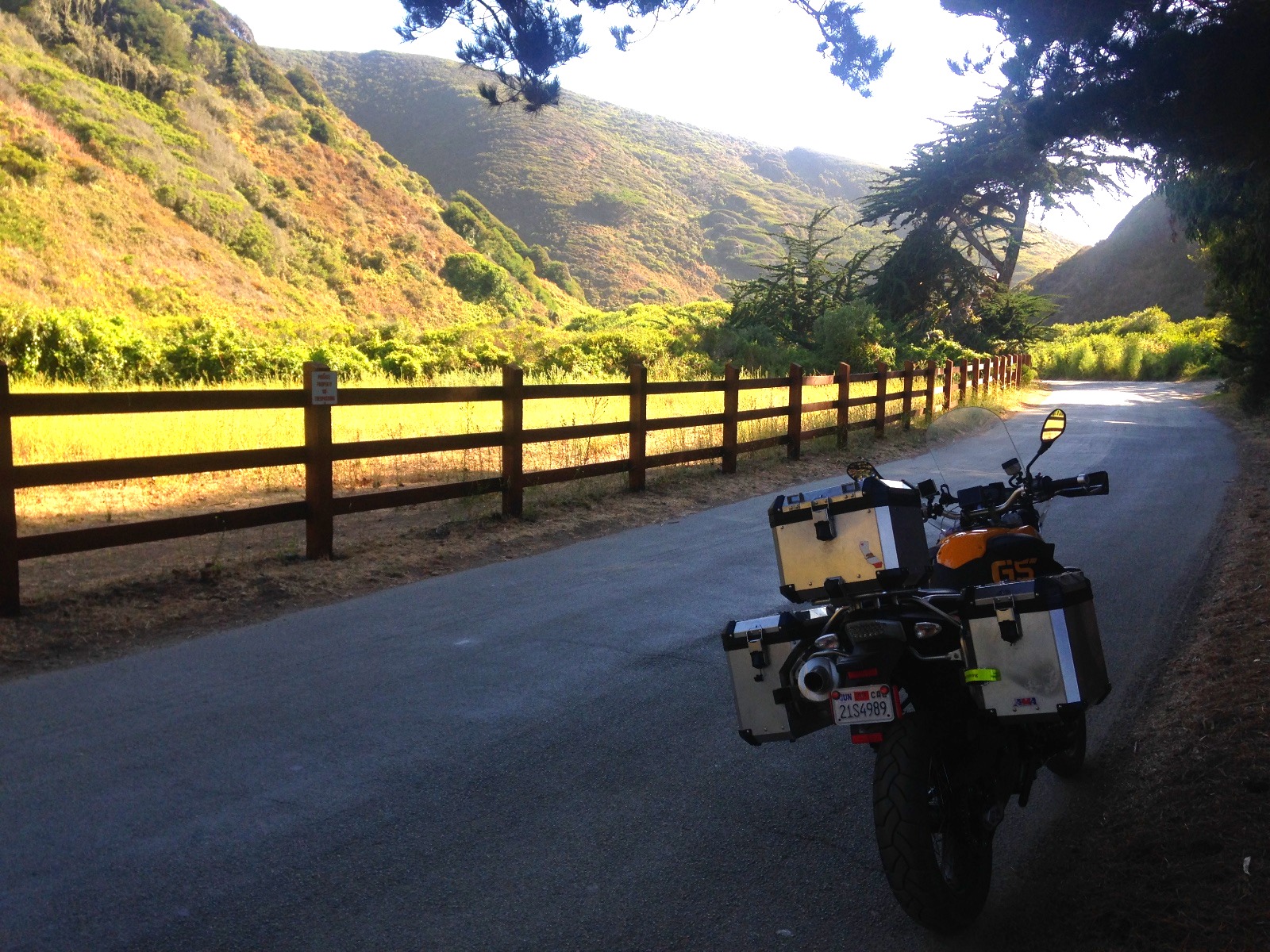 The motorcycle on a narrow lane behind a wooden fence in Big Sur