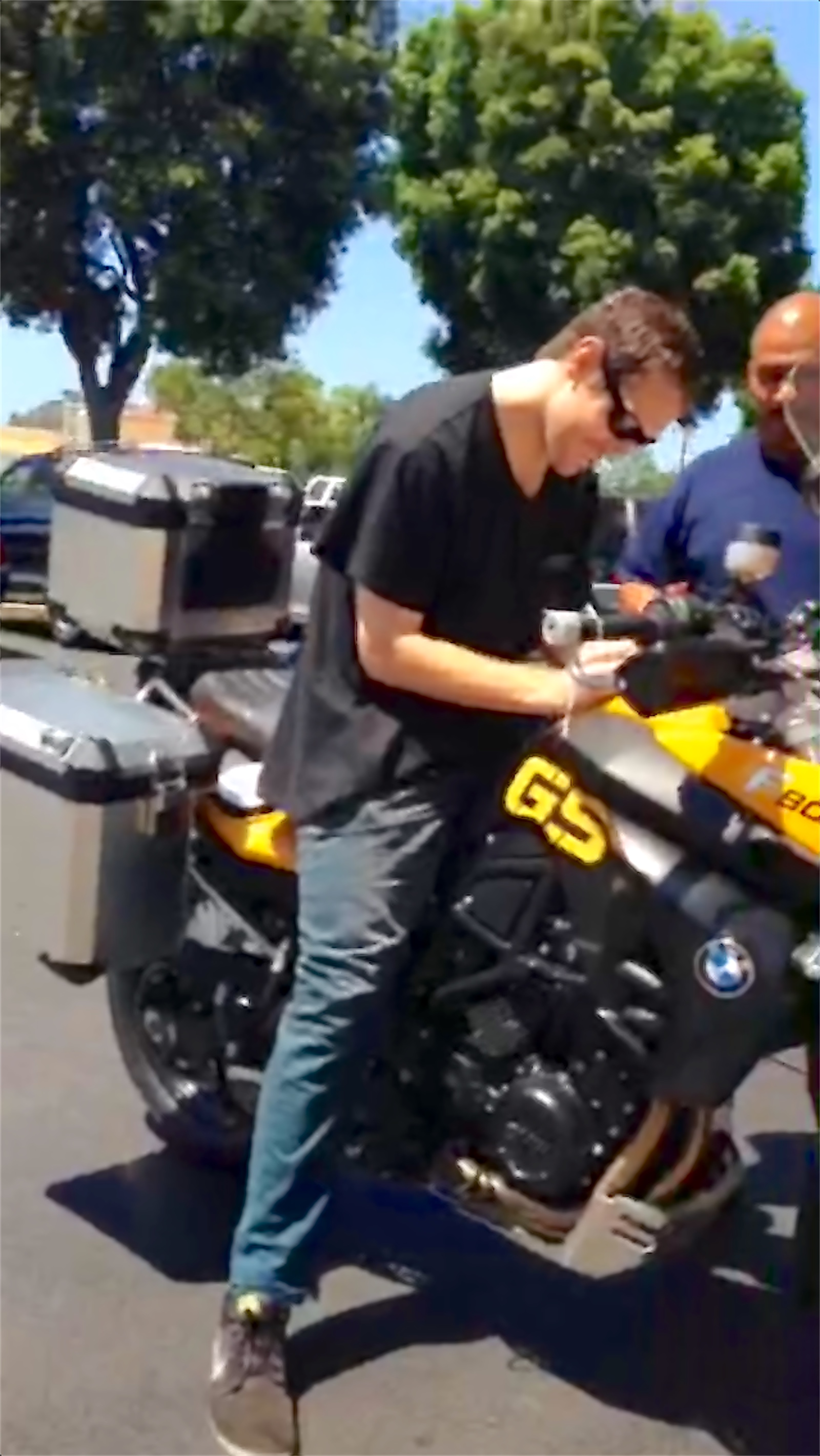 Rodrigo beside the motorcycle on the pavement after delivery