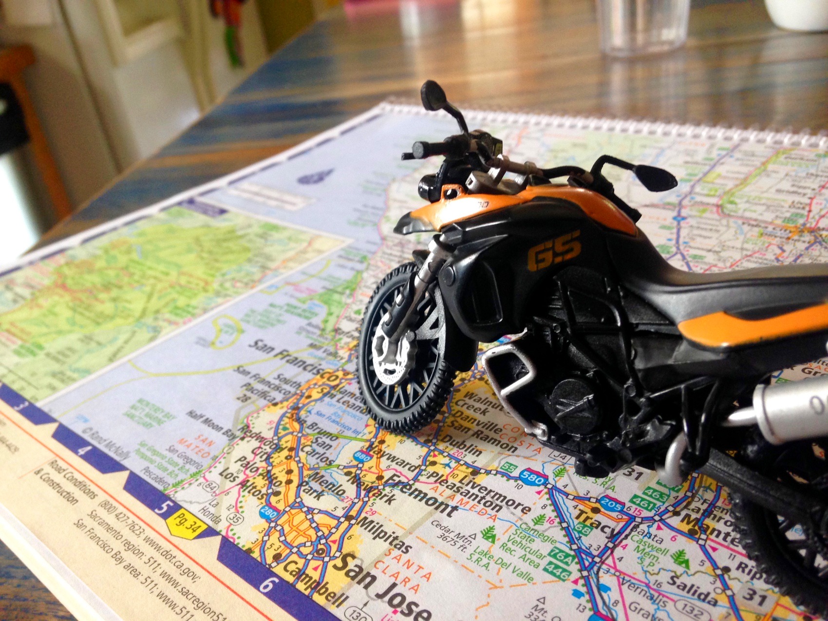 A toy BMW GS standing on a paper map of California open at the San Francisco Bay