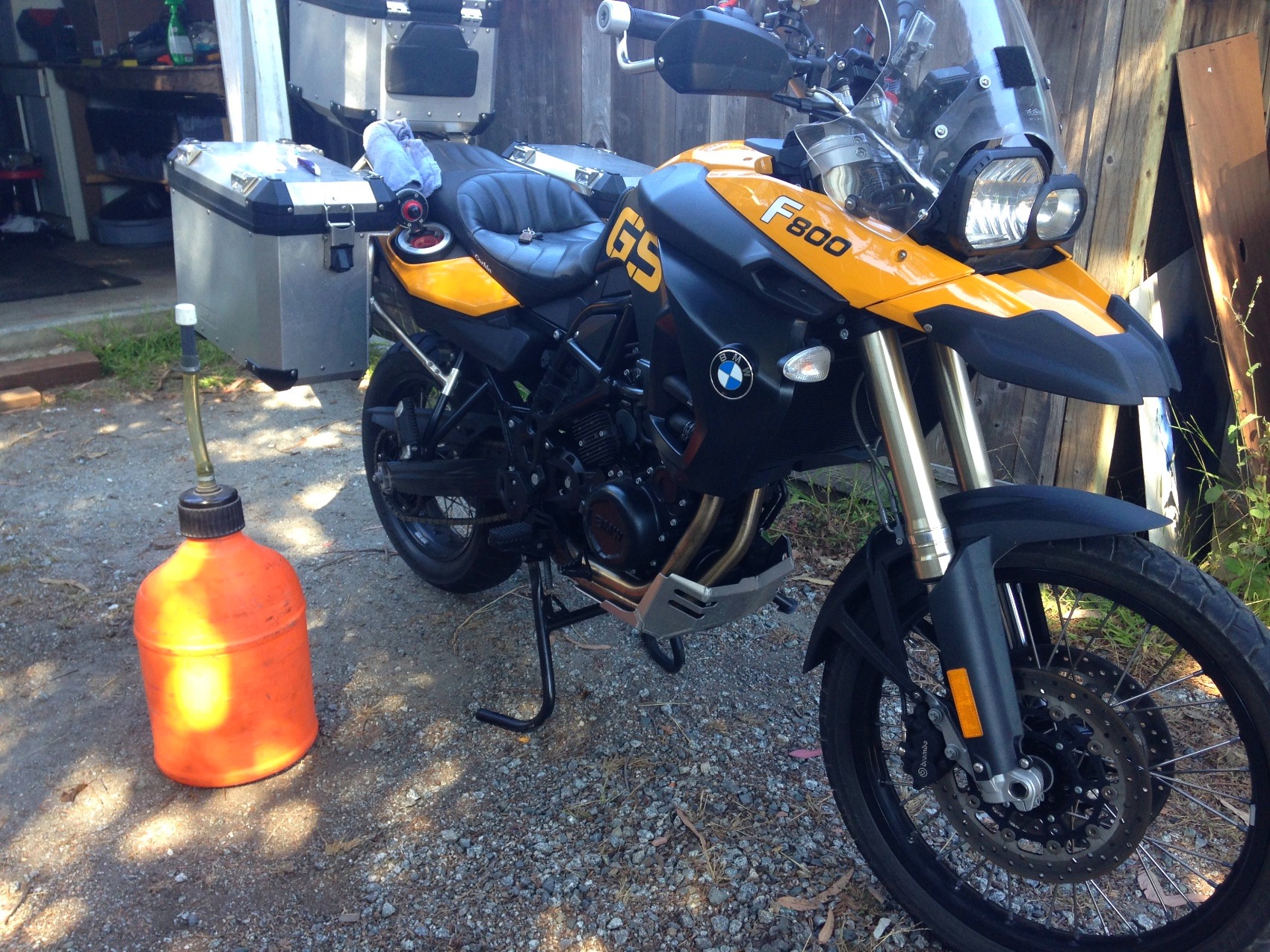 The yellow BMW in a gravel yard with an orange fuel can on the ground