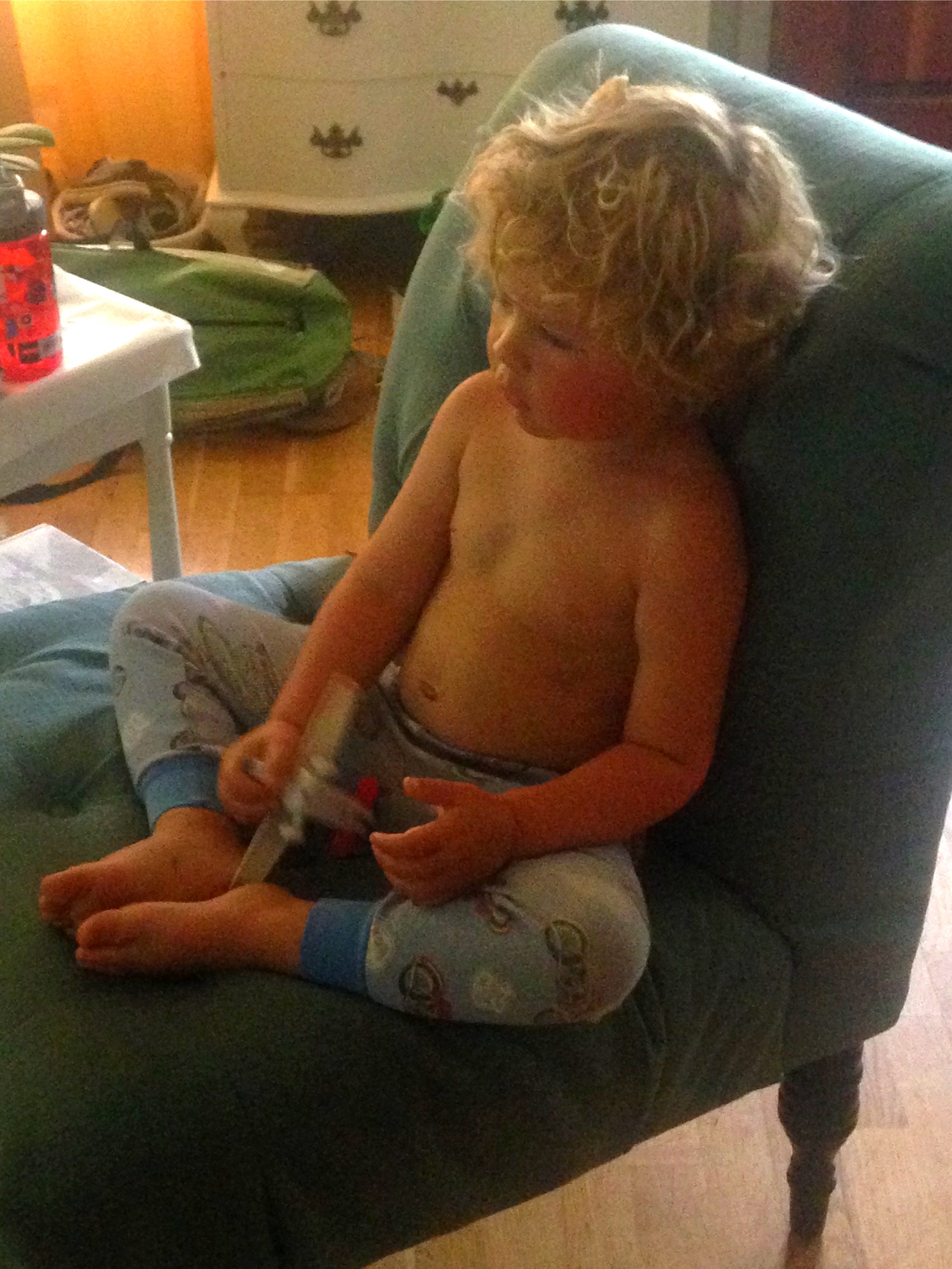A small blond boy sitting in an armchair