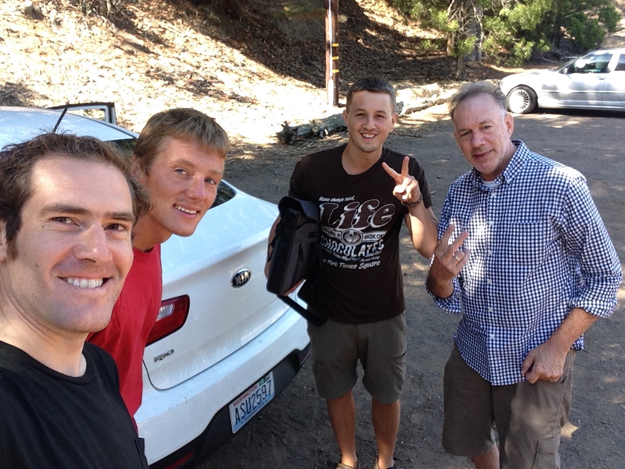 Four travellers beside a white car in the Marin hills