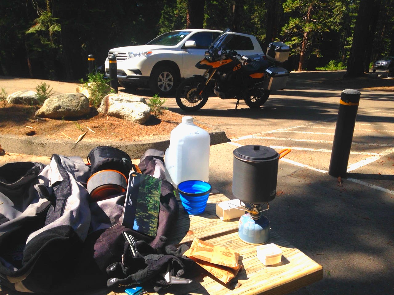 Camping gear and a stove laid out on a picnic table