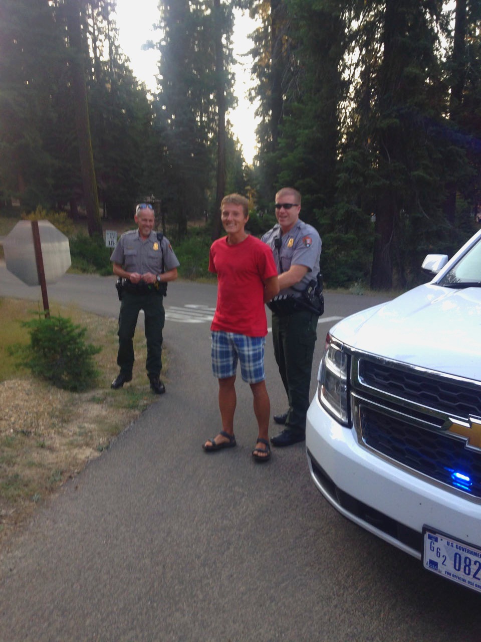 Rodrigo talking to two park rangers beside a patrol truck
