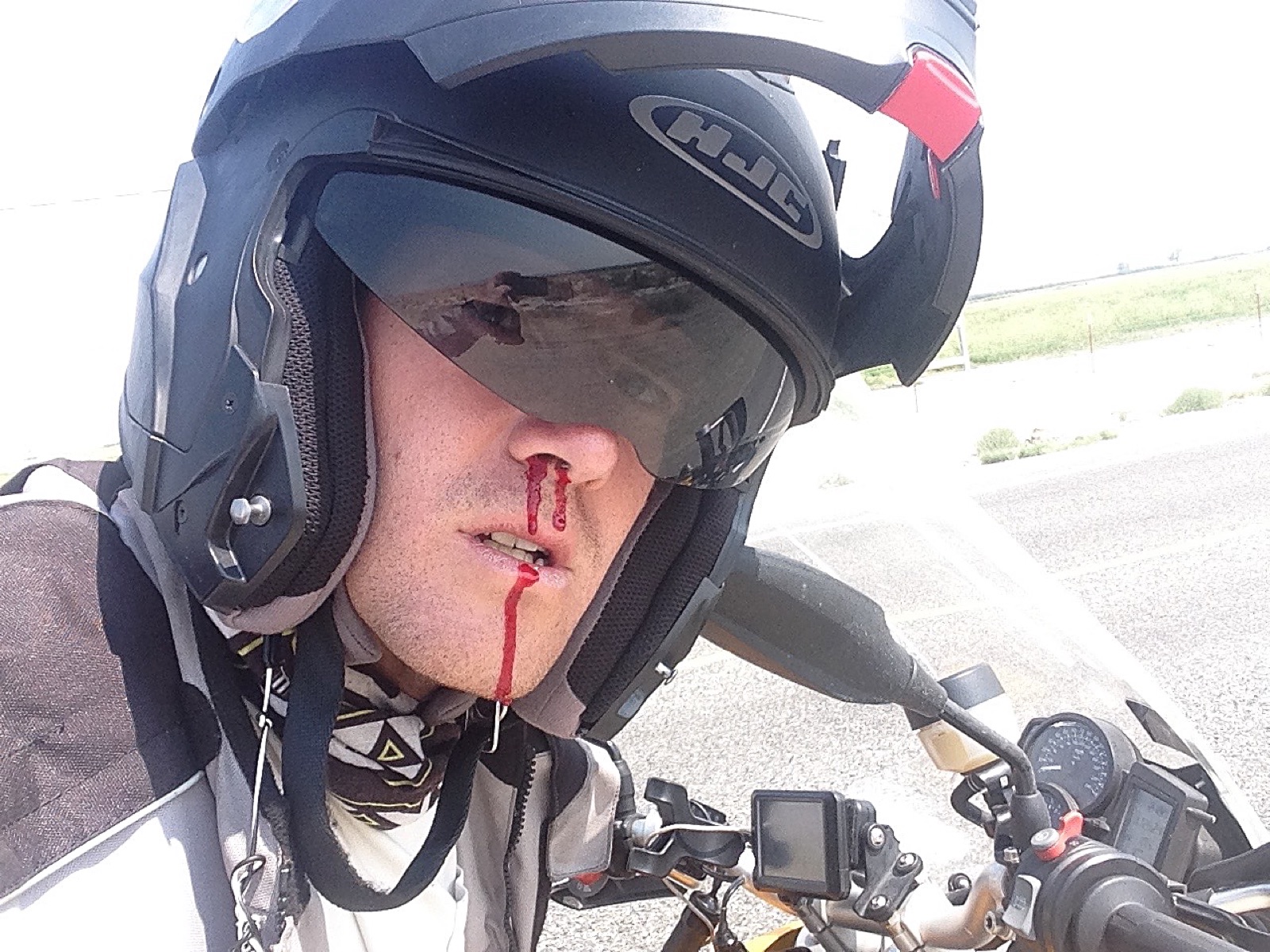 A selfie with a nosebleed, helmet still on, in Death Valley