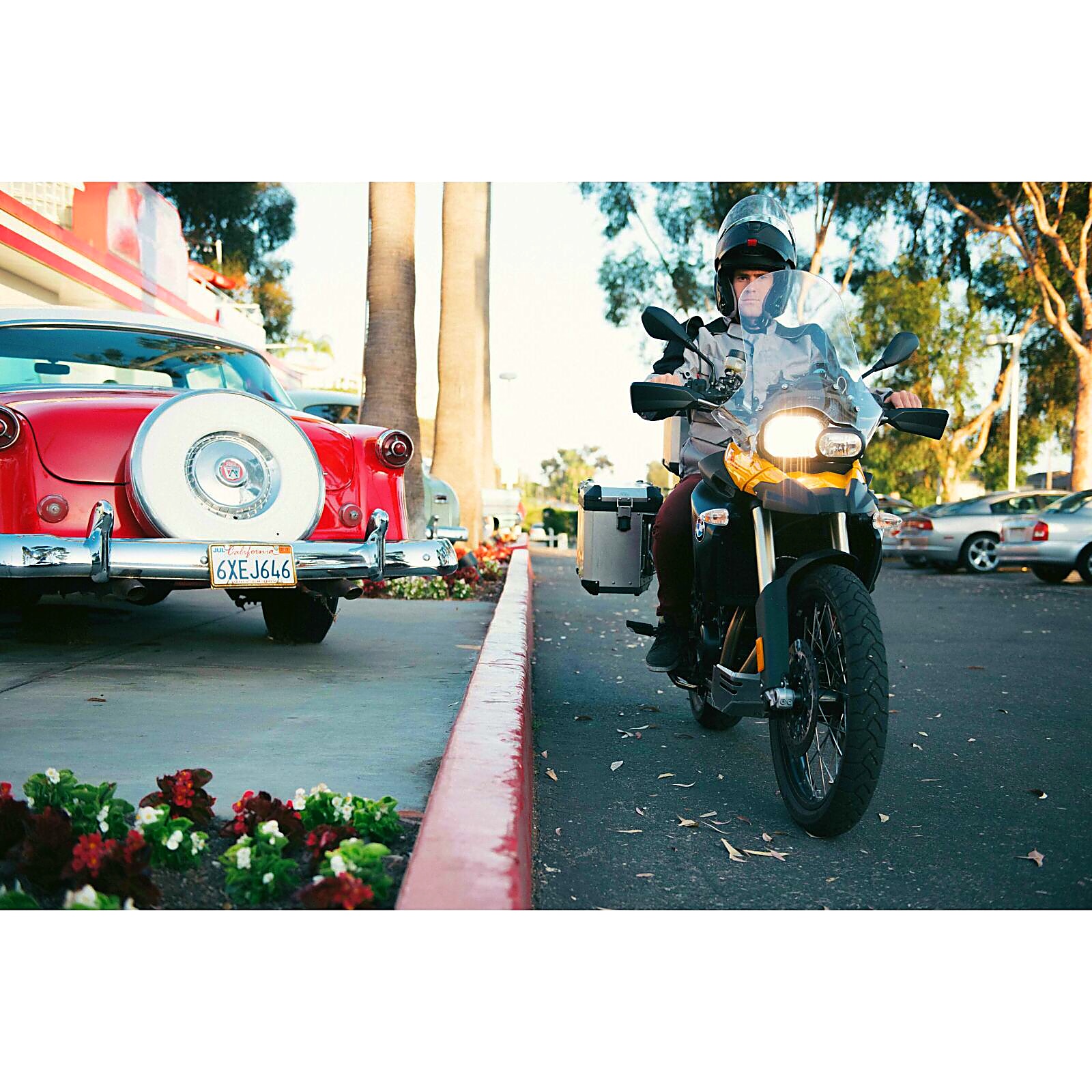 Rodrigo riding past a vintage car and palm trees