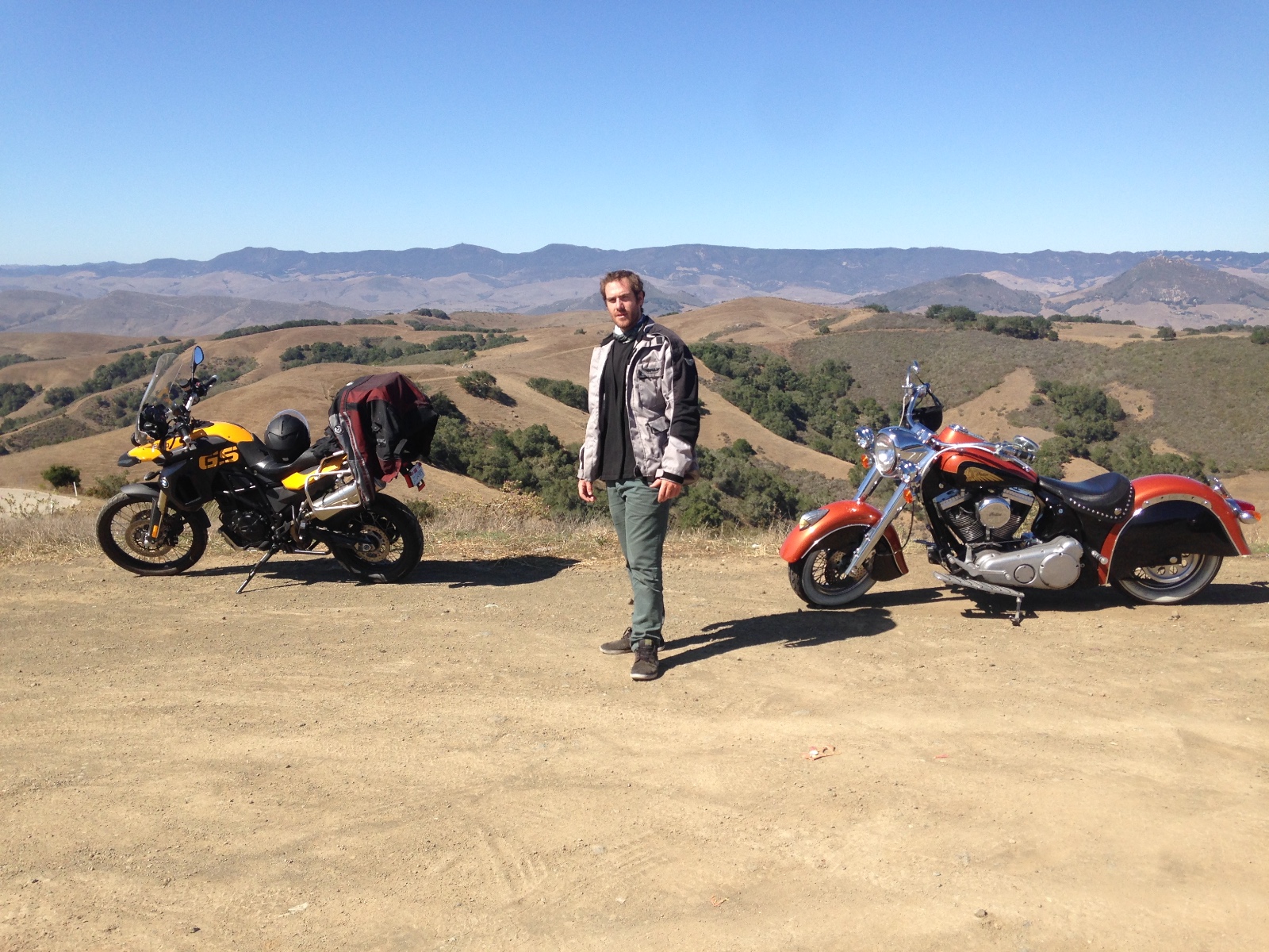 Rodrigo between his BMW and Randy's Indian in the golden hills