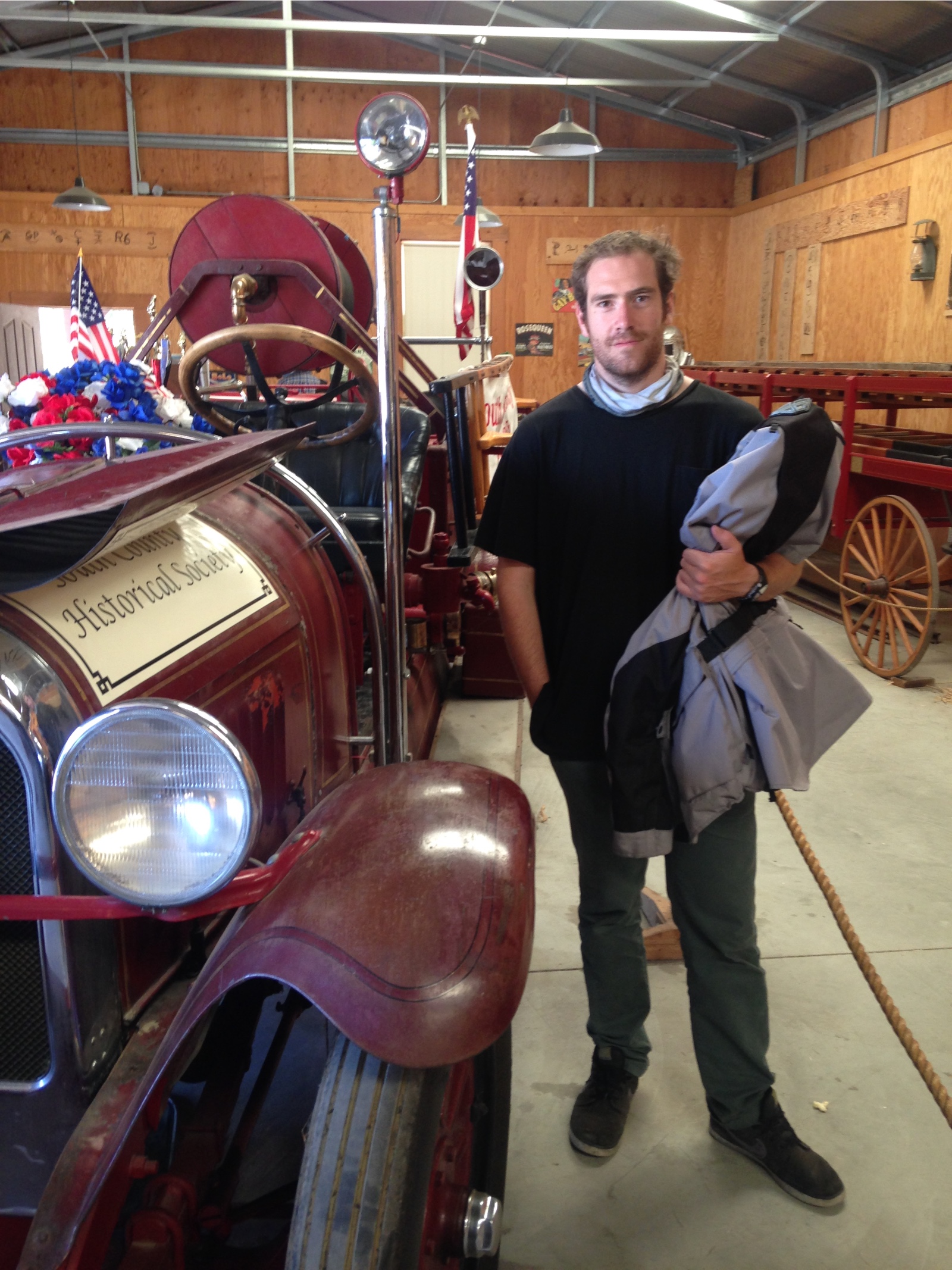 Rodrigo beside an antique fire engine at a vintage vehicle show