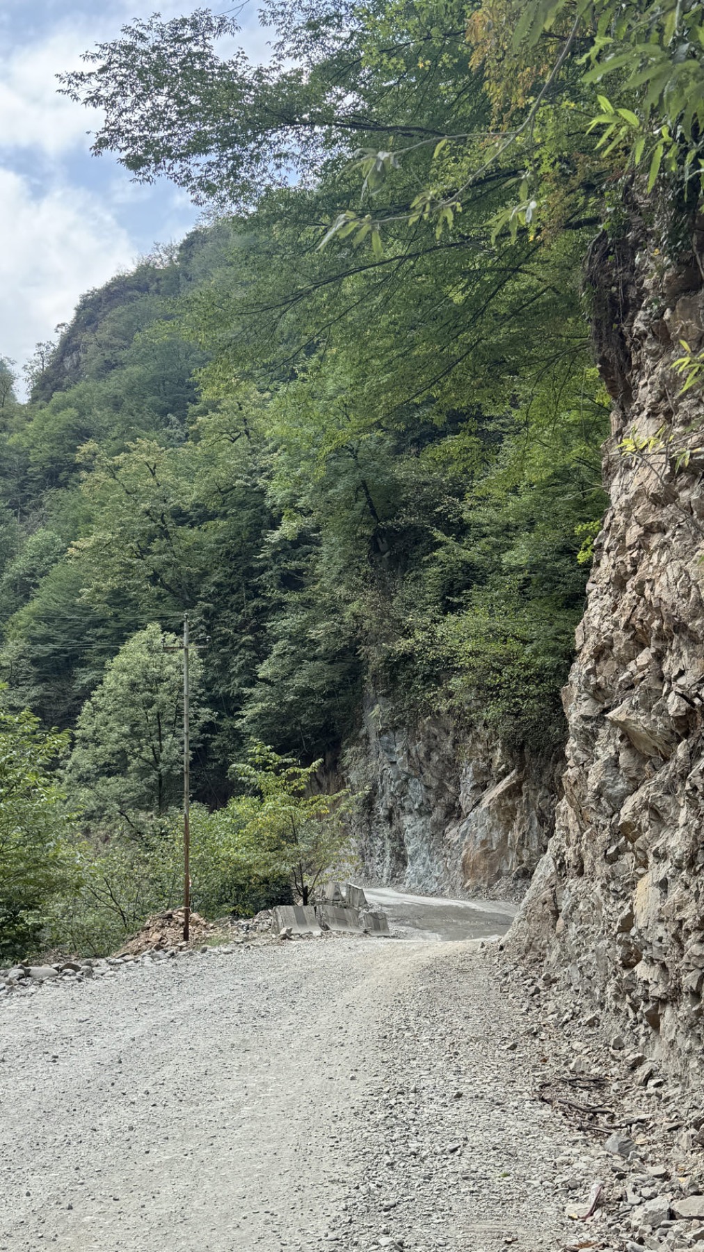 A narrow gravel road cut into a hillside
