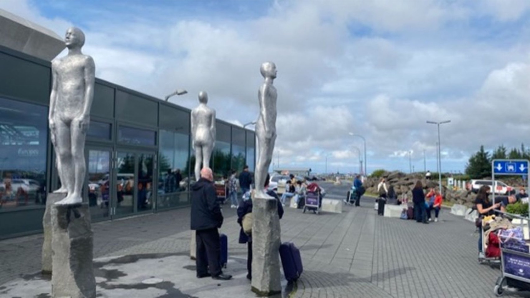 Silver human figures standing outside the terminal at Keflavik airport