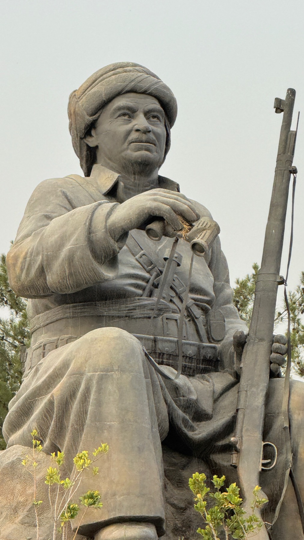 A stone statue of a Kurdish fighter with a rifle