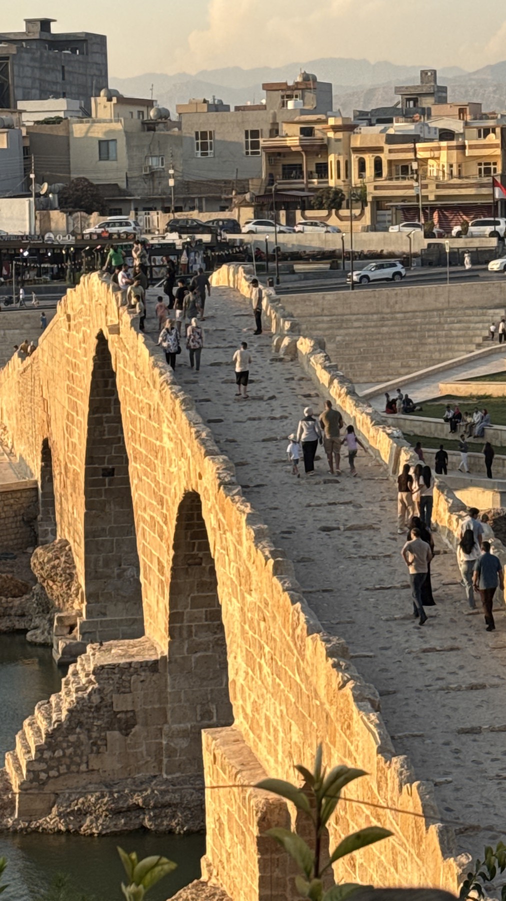 The old stone arch bridge at Zakho crowded at sunset