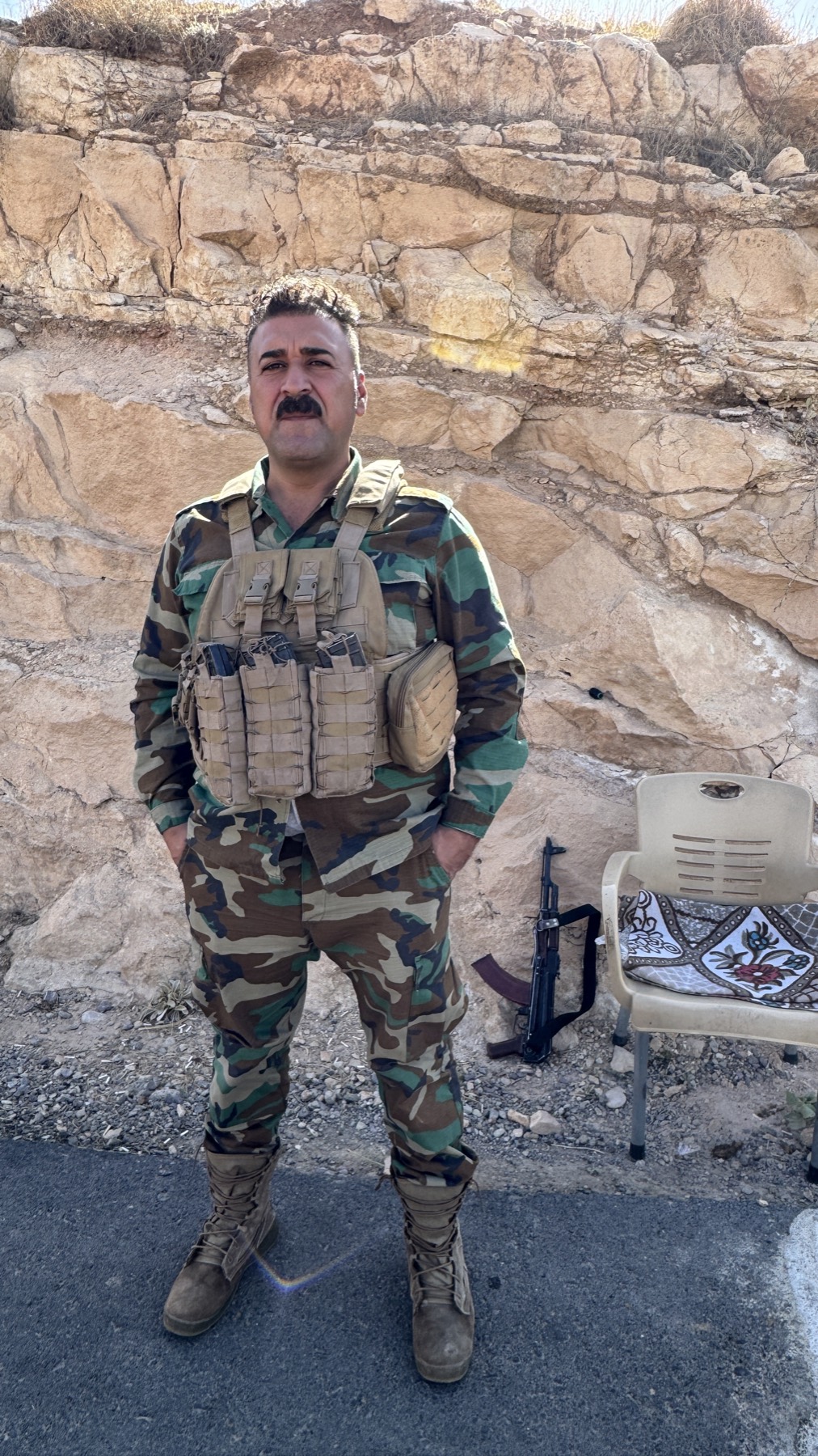 A Peshmerga soldier standing on the rock in mountain country