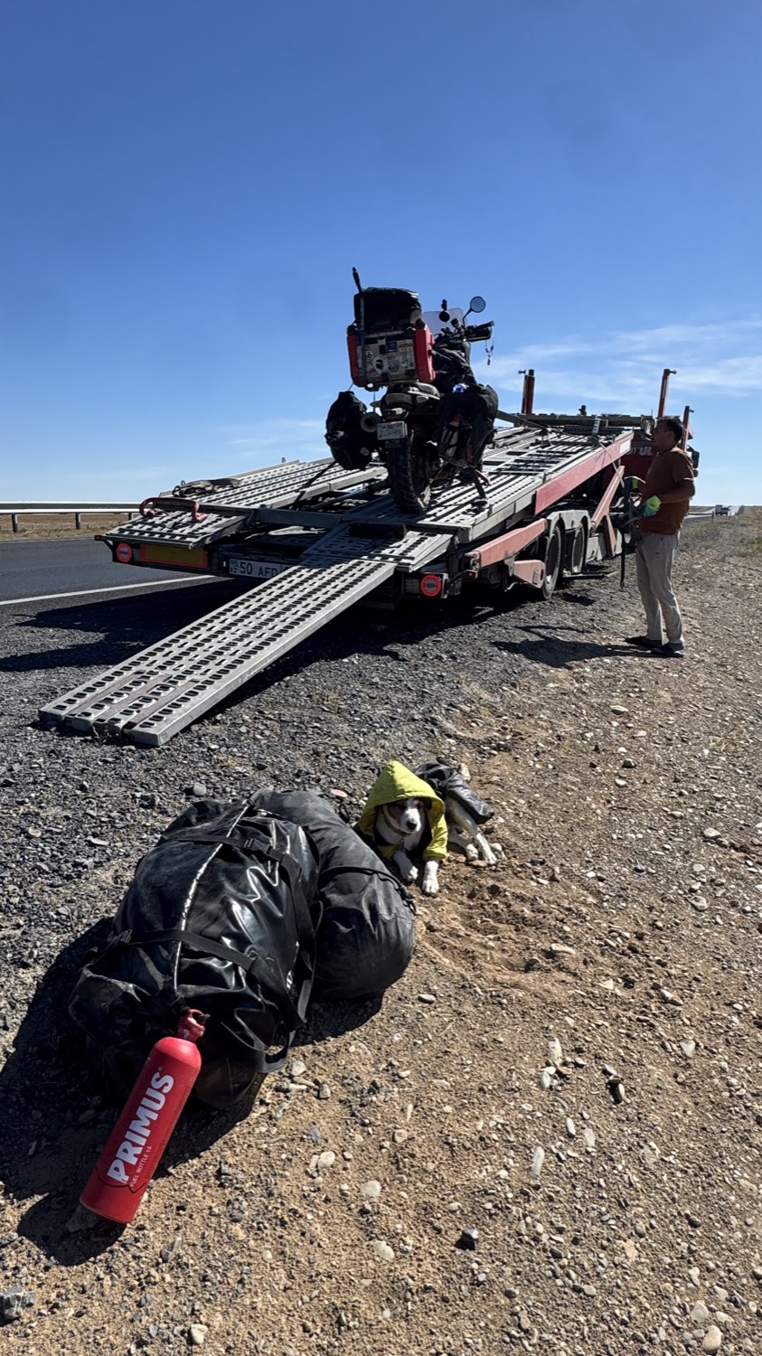 The lowered ramp of a tow lorry with luggage on the ground beside it