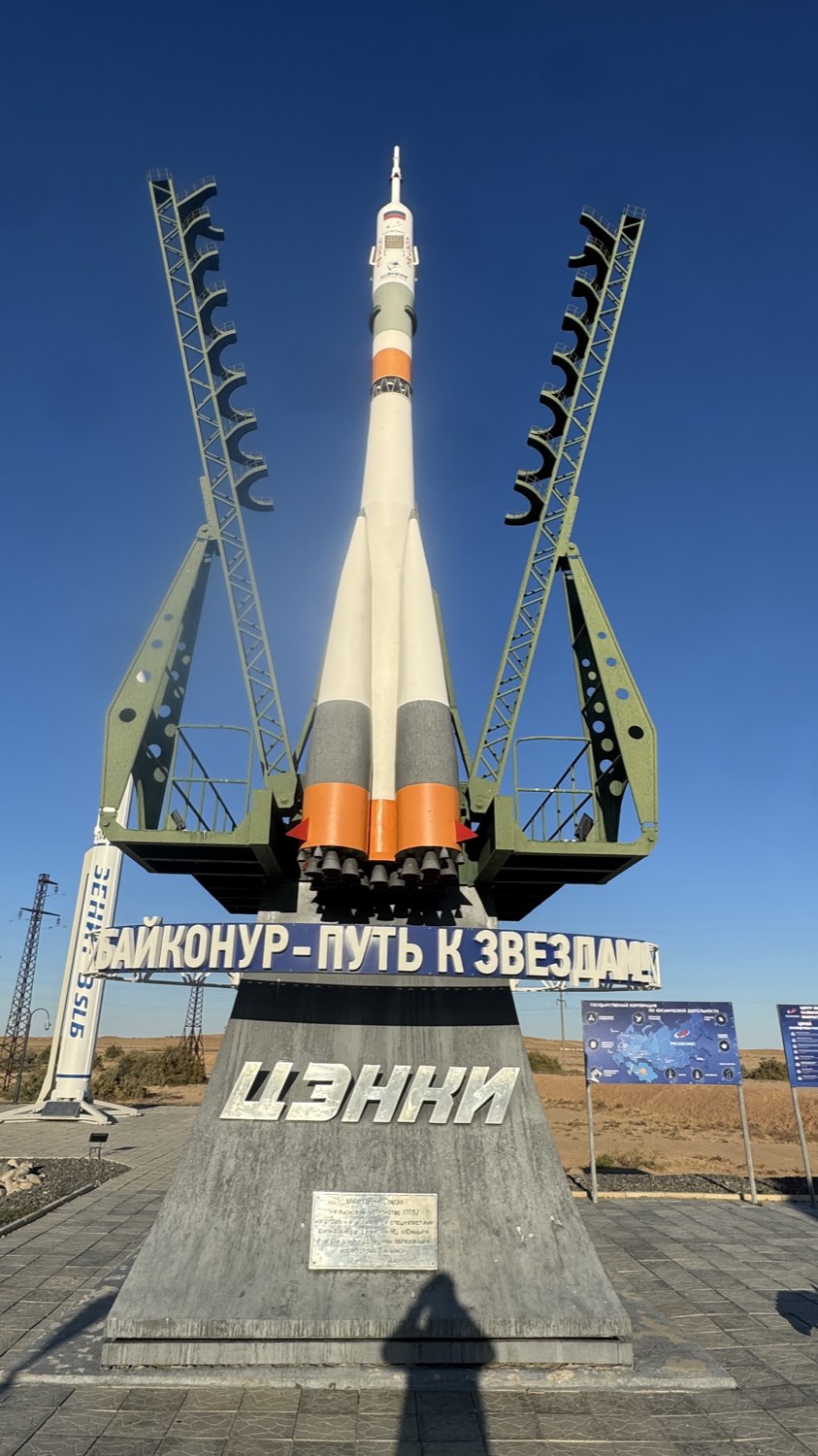 A full size Soyuz rocket monument standing between its green service towers