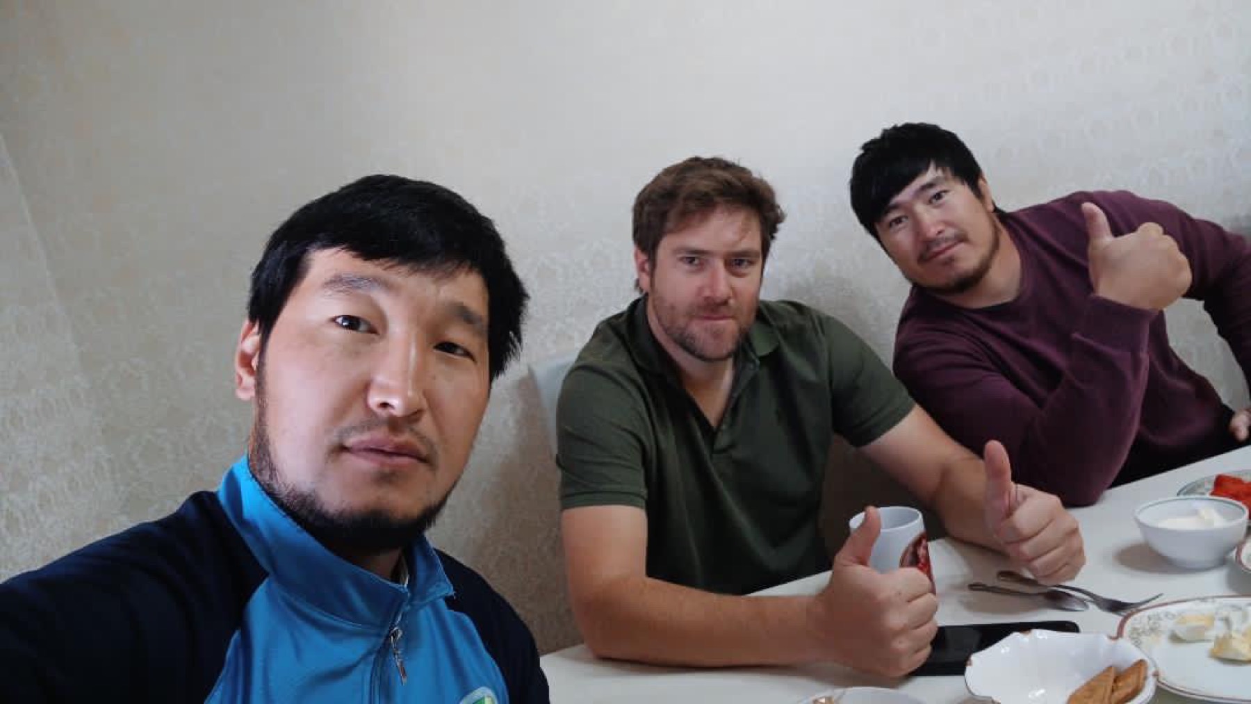 Rodrigo at a breakfast table with two Kazakh men