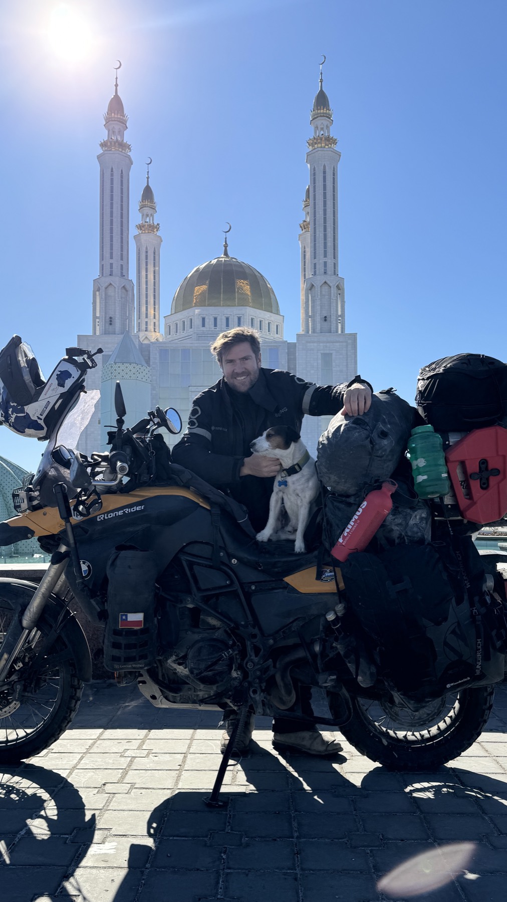 Rodrigo and Jacko with the motorcycle in front of a mosque with a golden dome