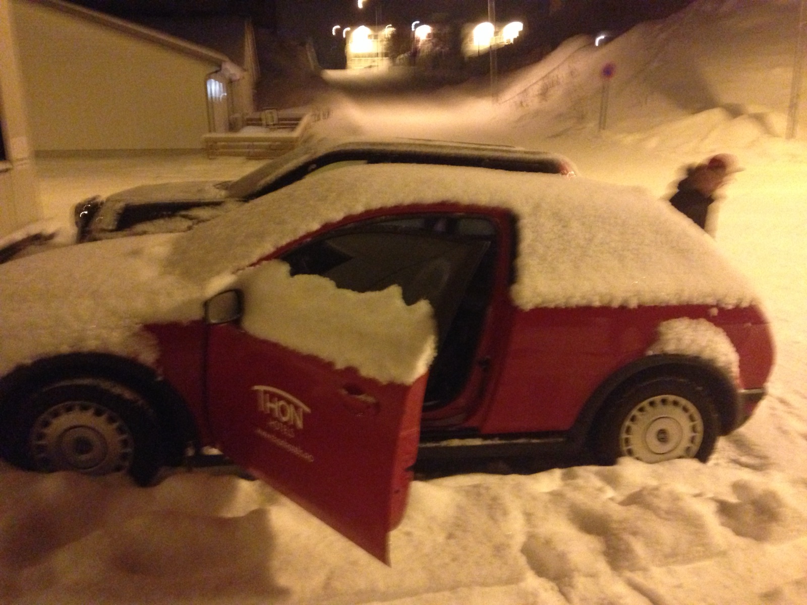 A red hotel car completely buried in snow