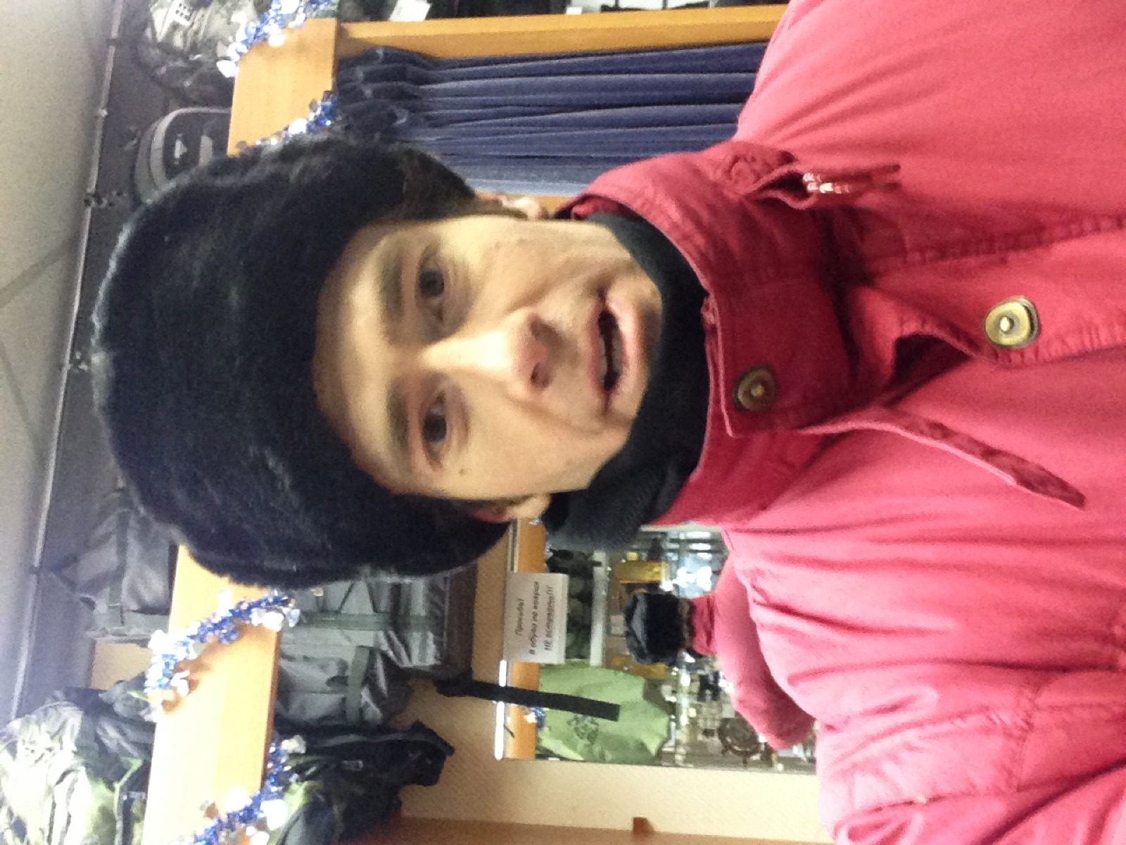 Rodrigo trying on a black ushanka in a Murmansk shop