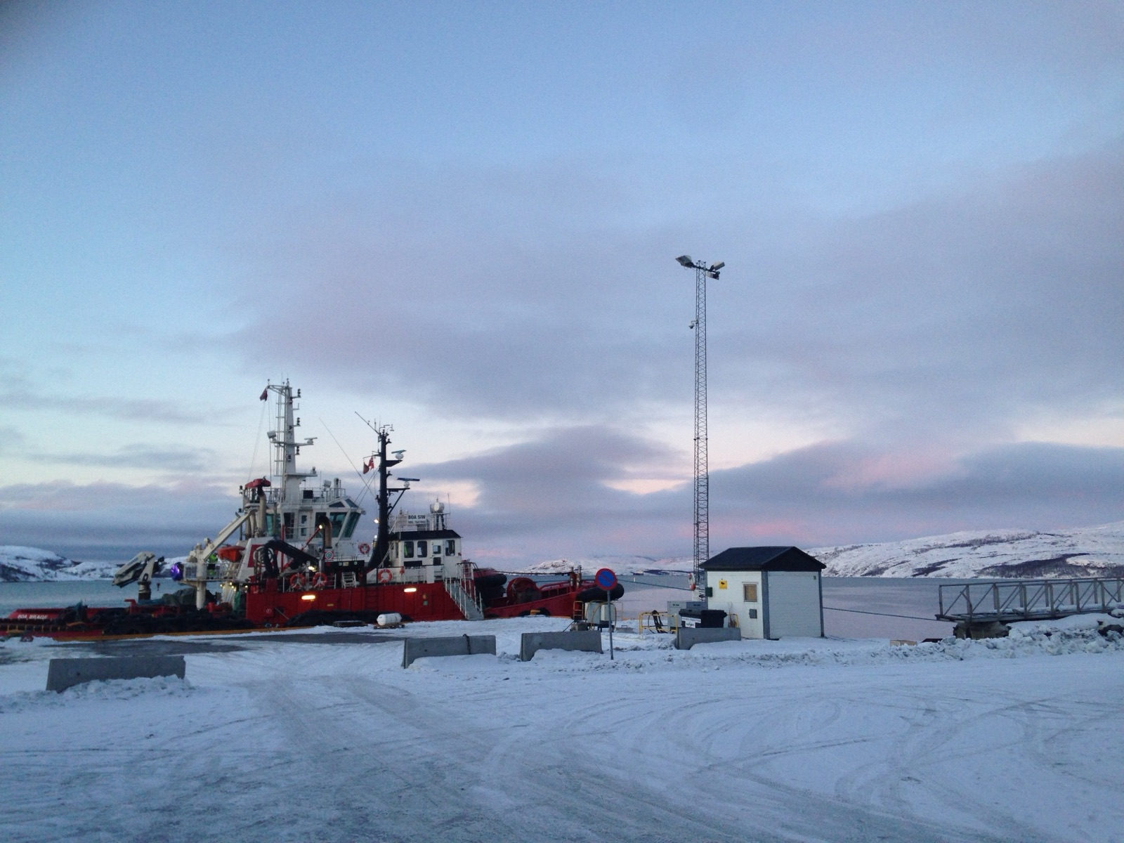 The same tugboat at the Kirkenes quay, now in daylight under a pink sky