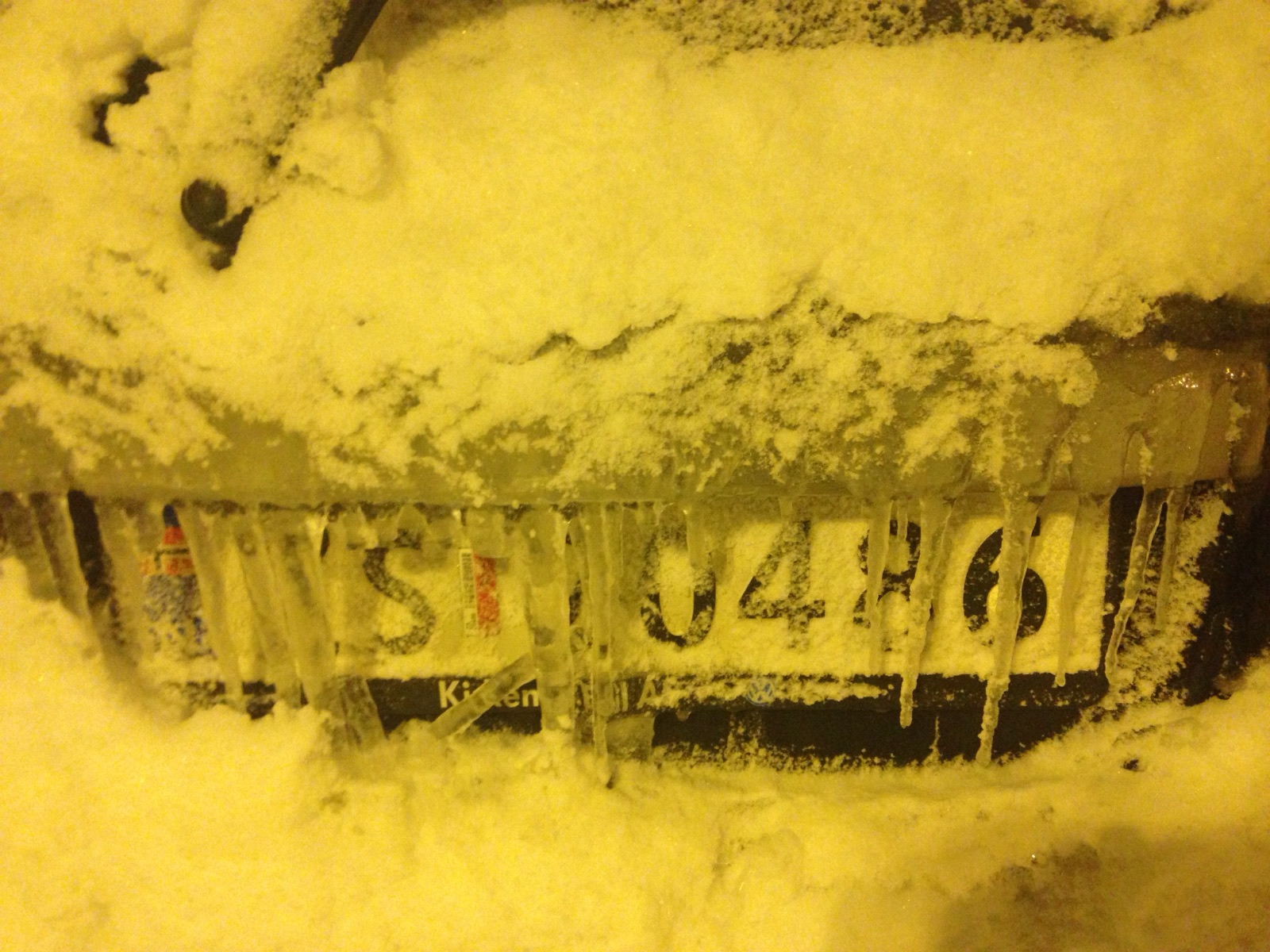 A number plate showing through a crust of ice