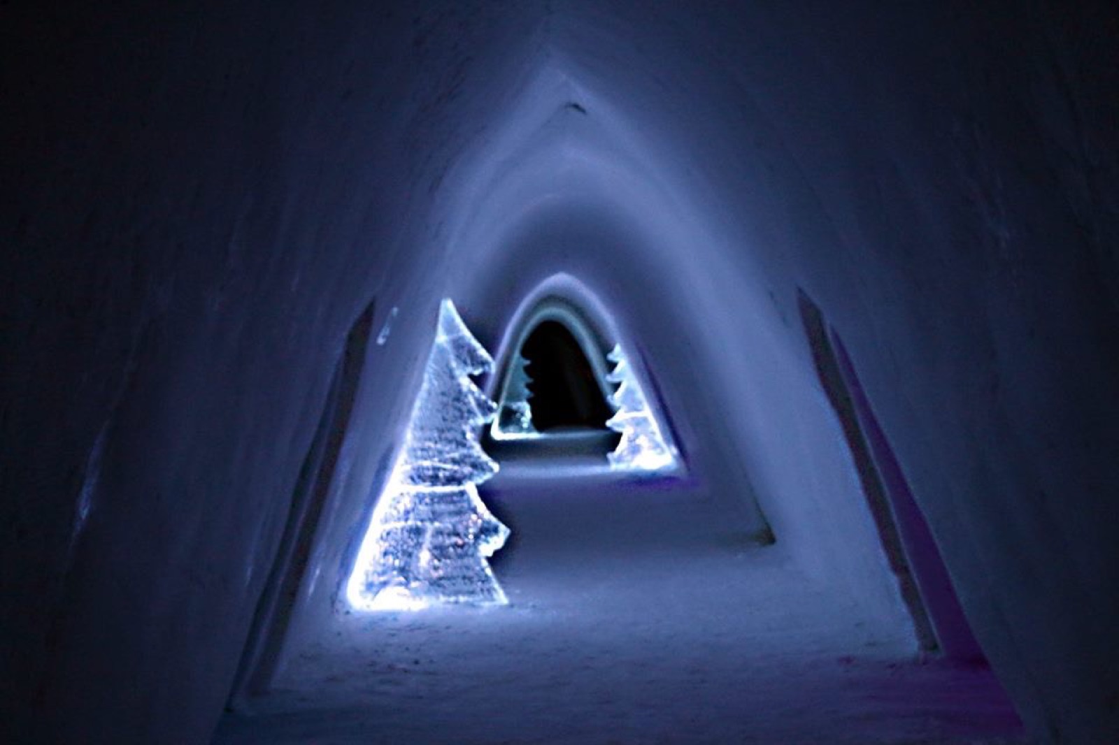 An ice corridor with a Christmas tree carved into the wall