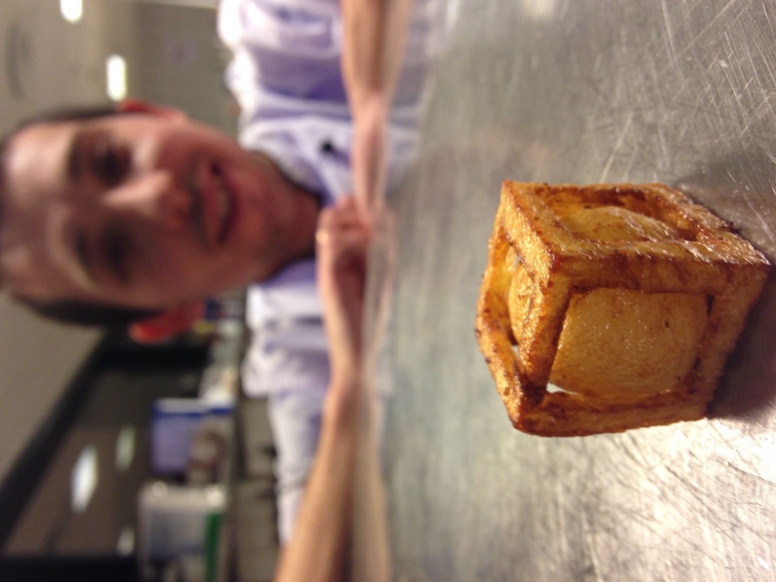 A cook leaning on the steel counter, laughing