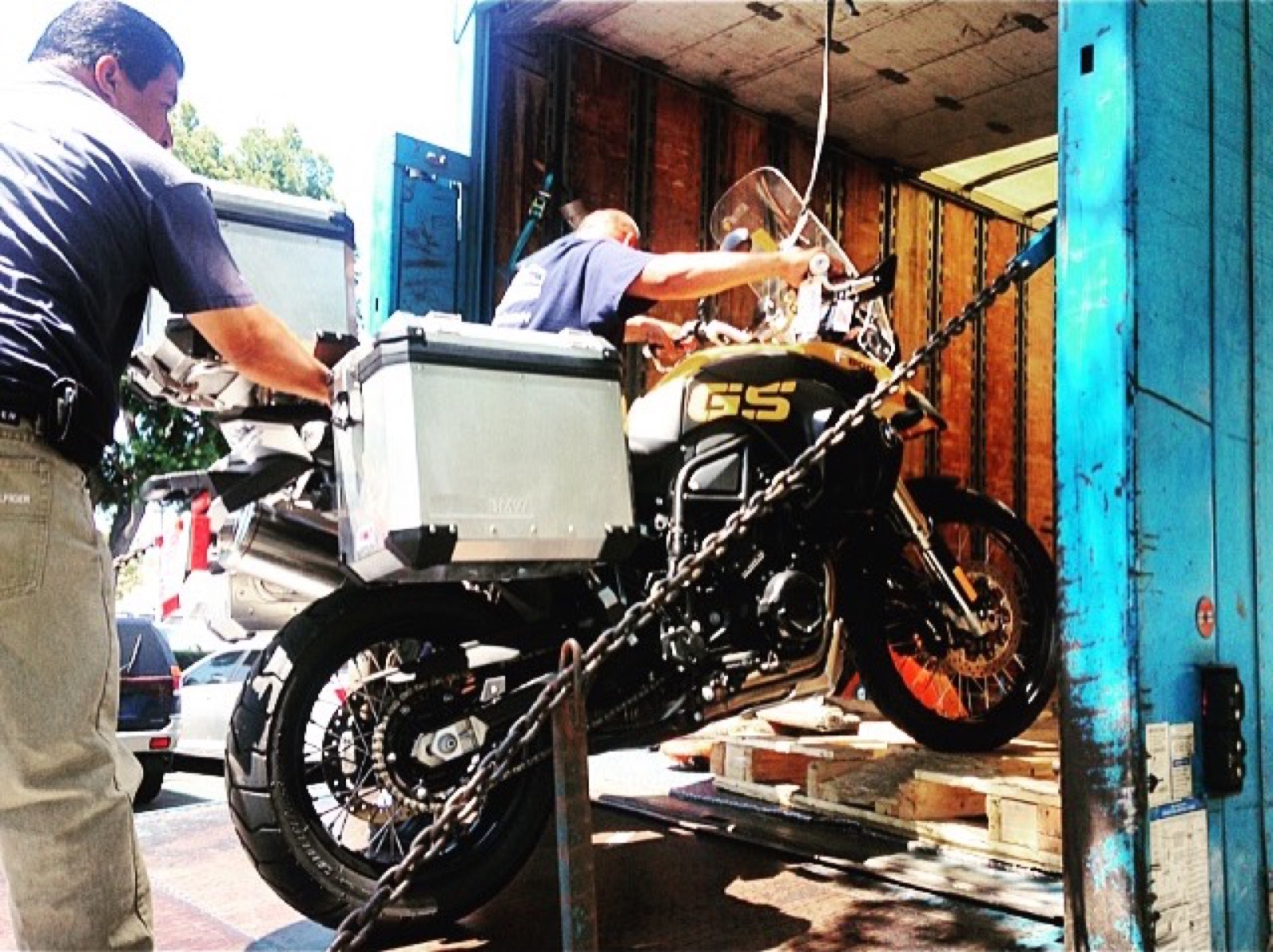 The yellow and black BMW F800 GS being loaded into a shipping container