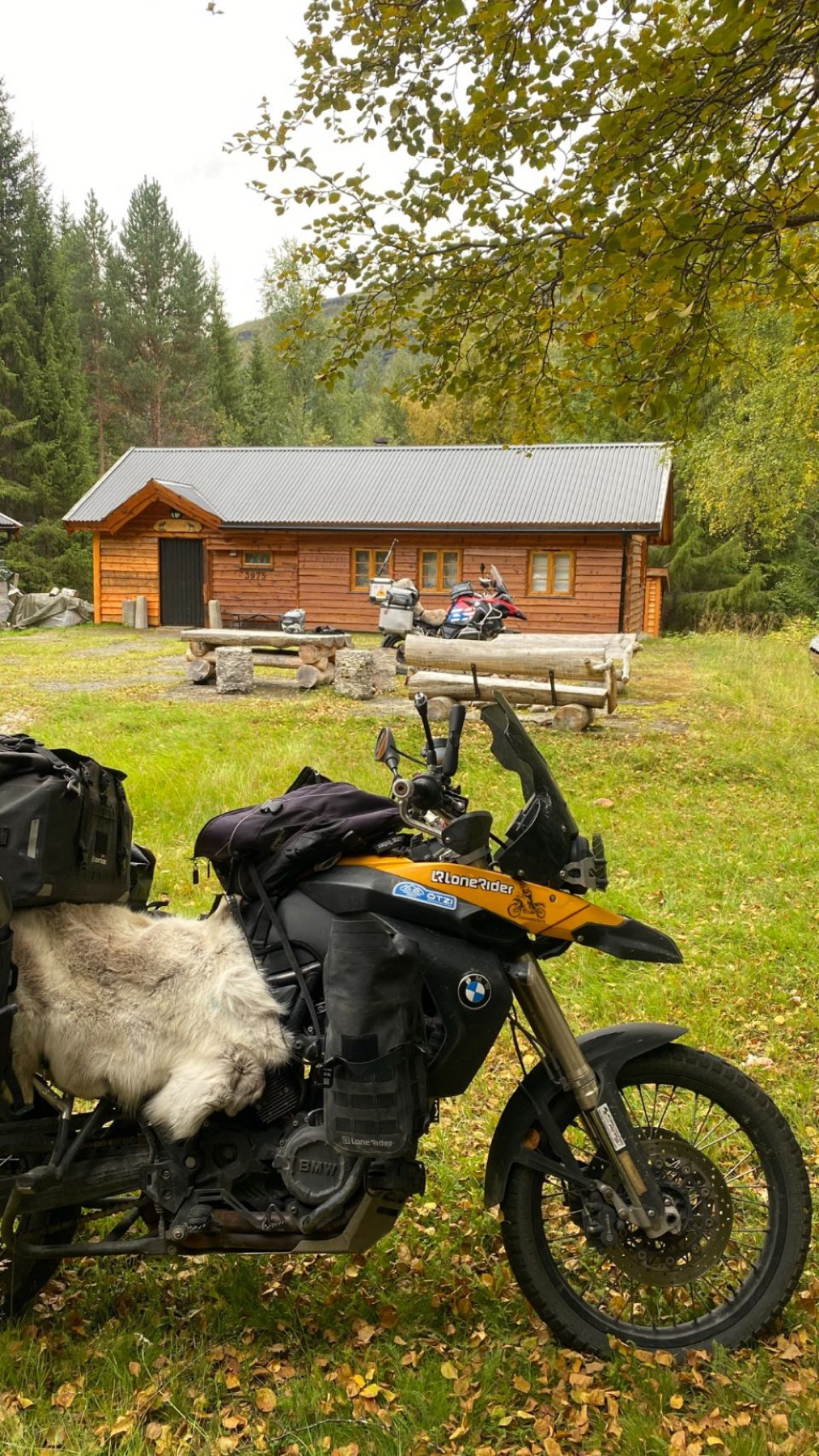 The loaded motorcycle in front of a wooden cabin