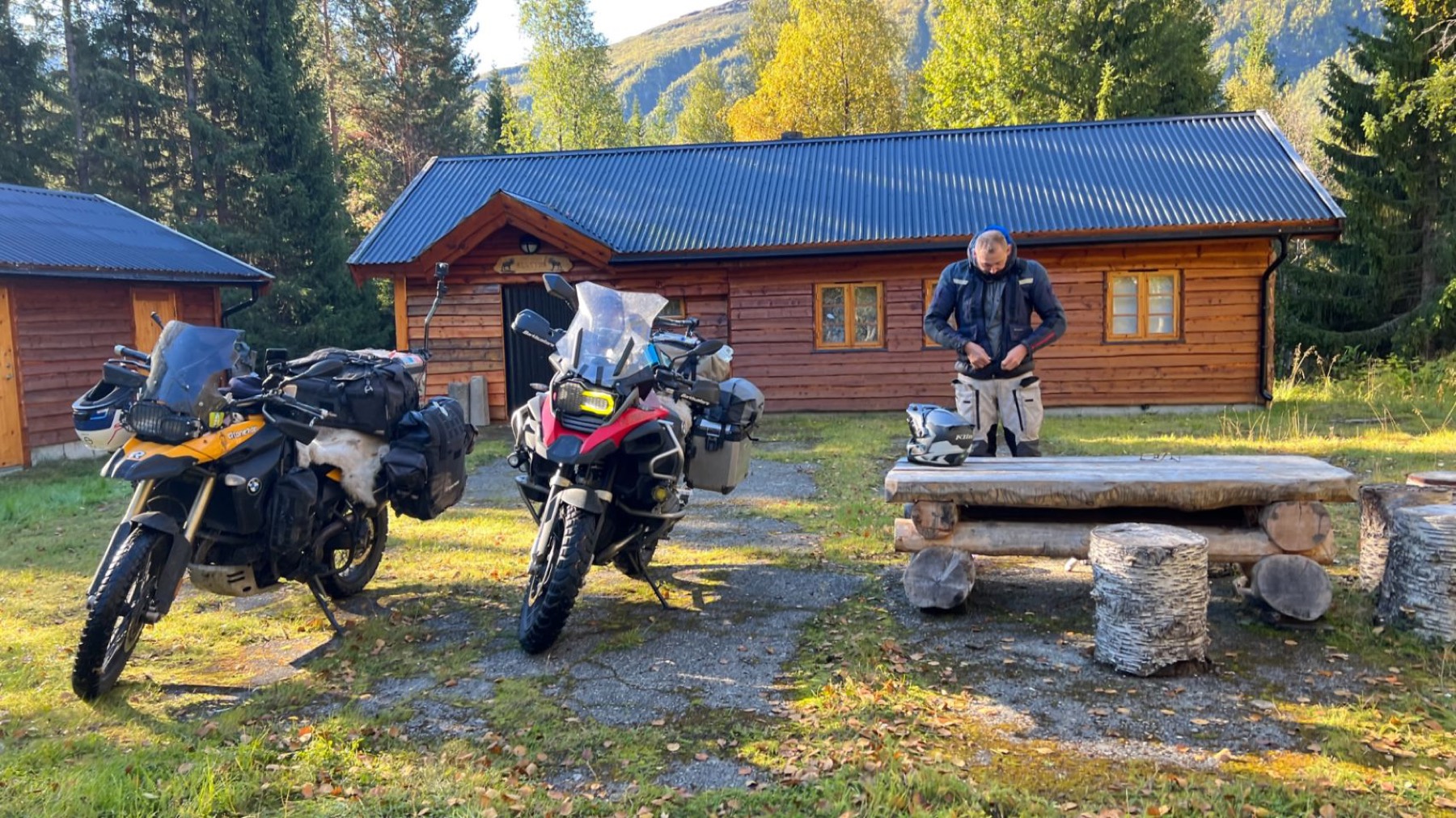 Two motorcycles parked outside a log cabin
