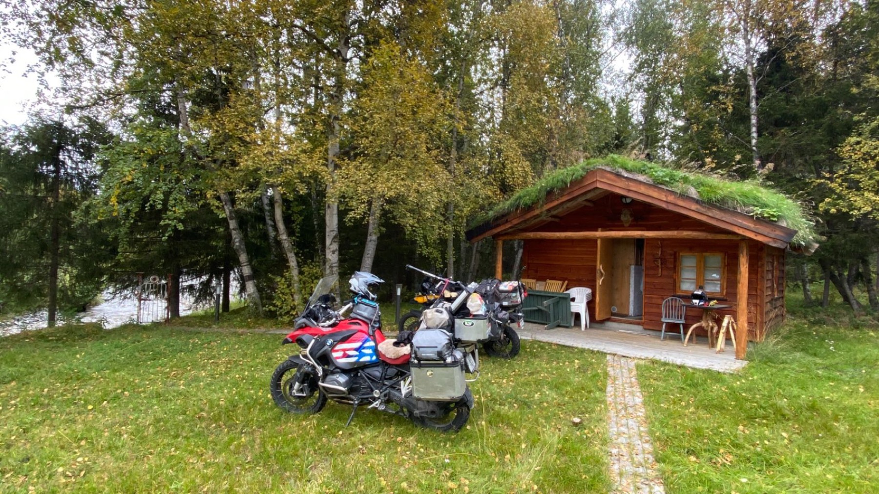 A small cabin with grass growing on its roof