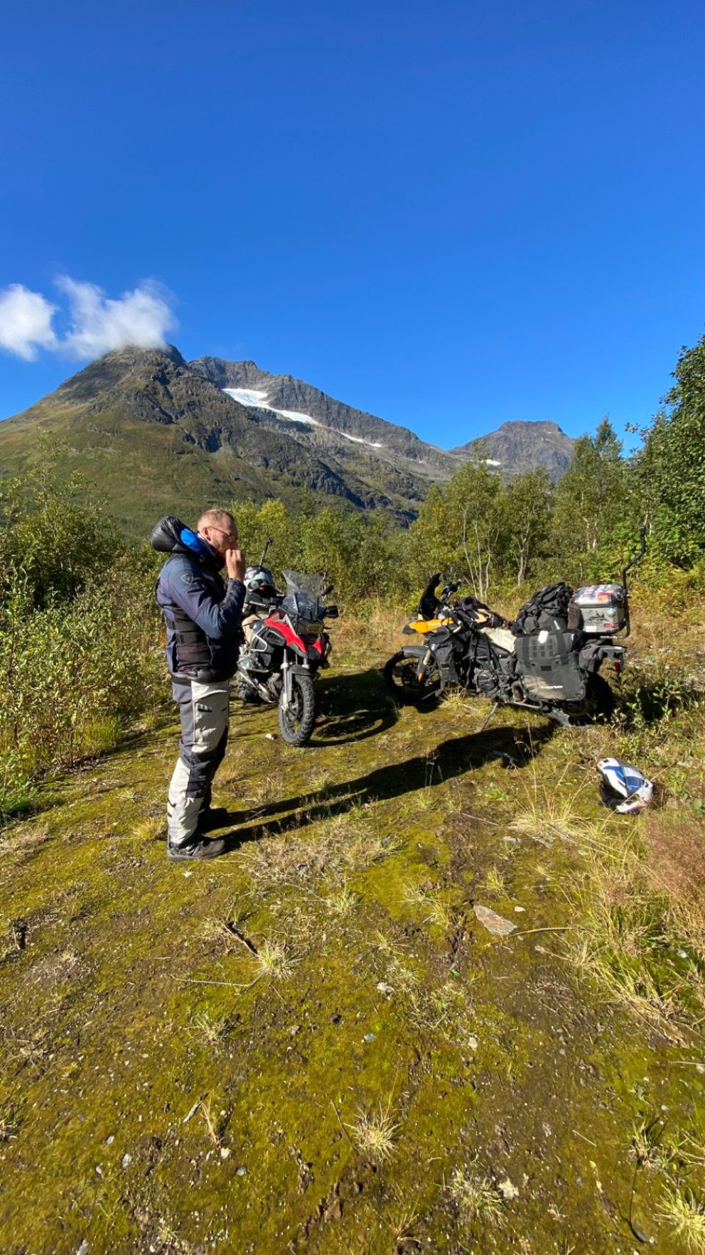 Two riders and their motorcycles on open tundra