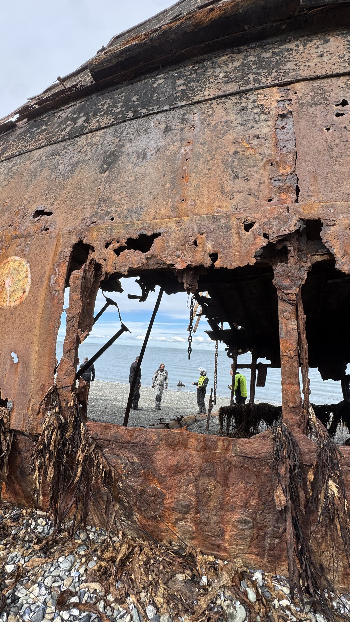 Riders framed by a weathered shipwreck