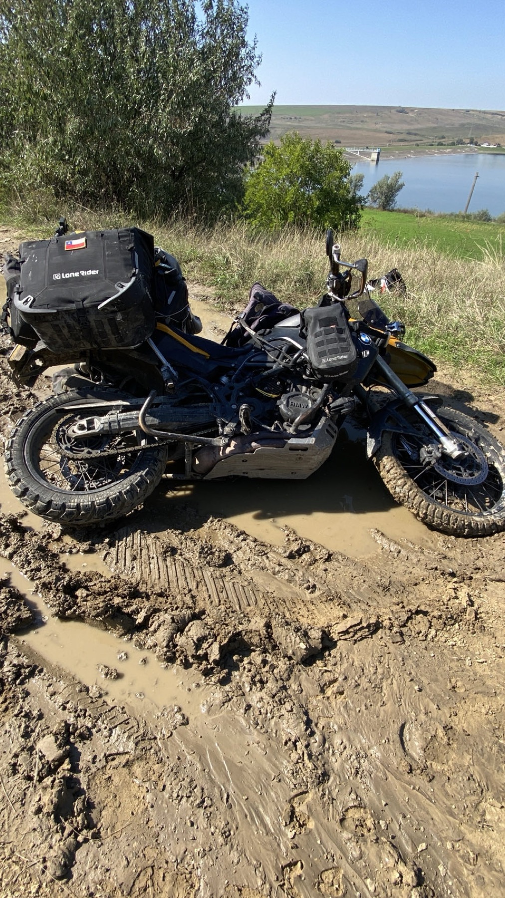 The motorcycle lying on its side in deep mud on a dirt track