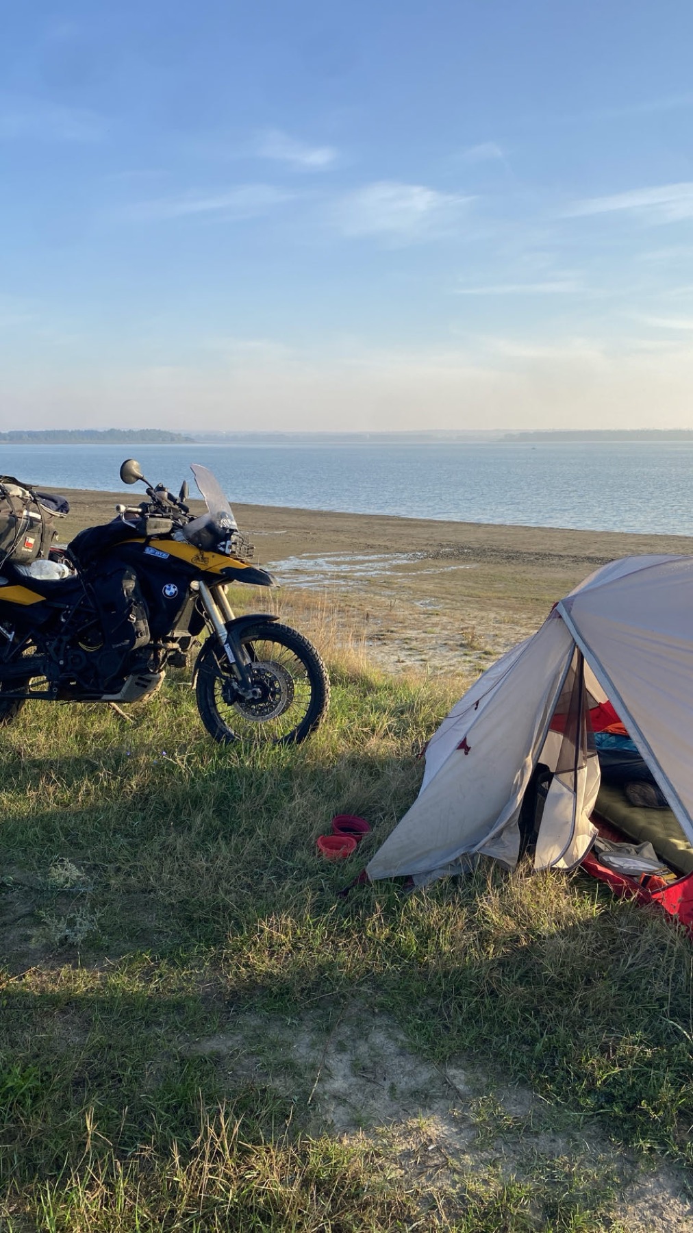 The tent and the loaded motorcycle above the water in the morning
