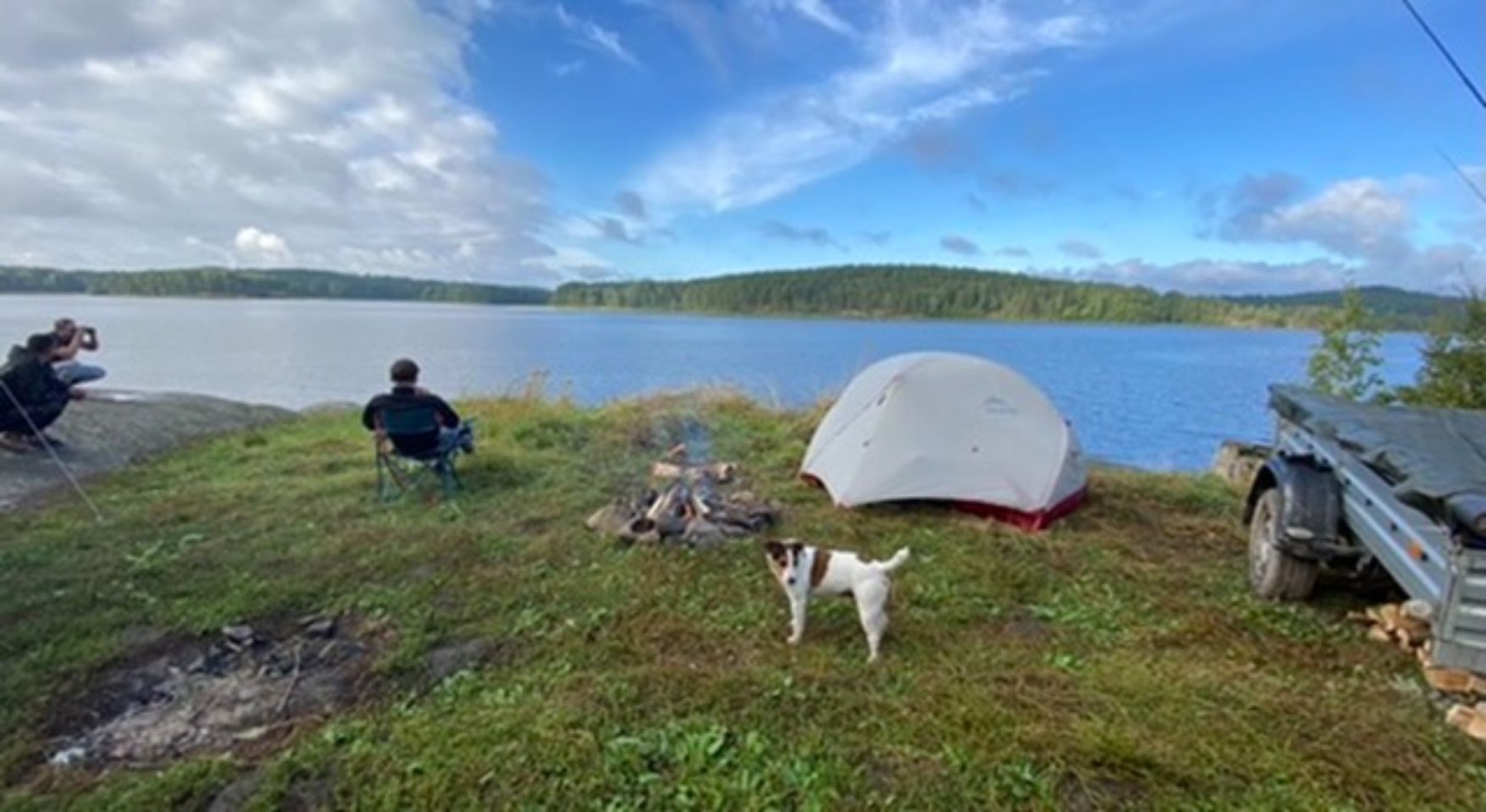 The tent and motorcycle on the shore of a wide lake