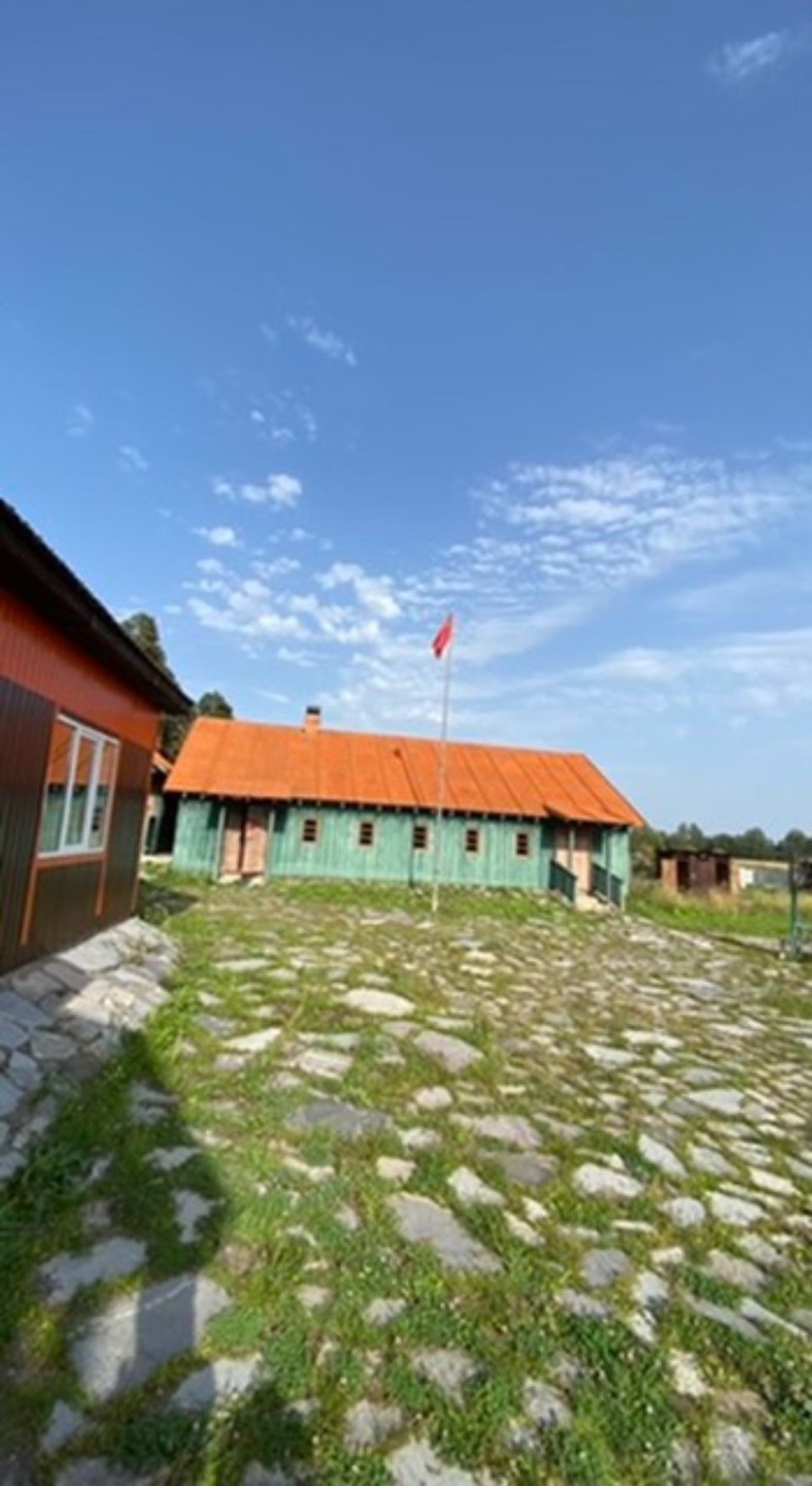 Timber farm buildings under a blue sky