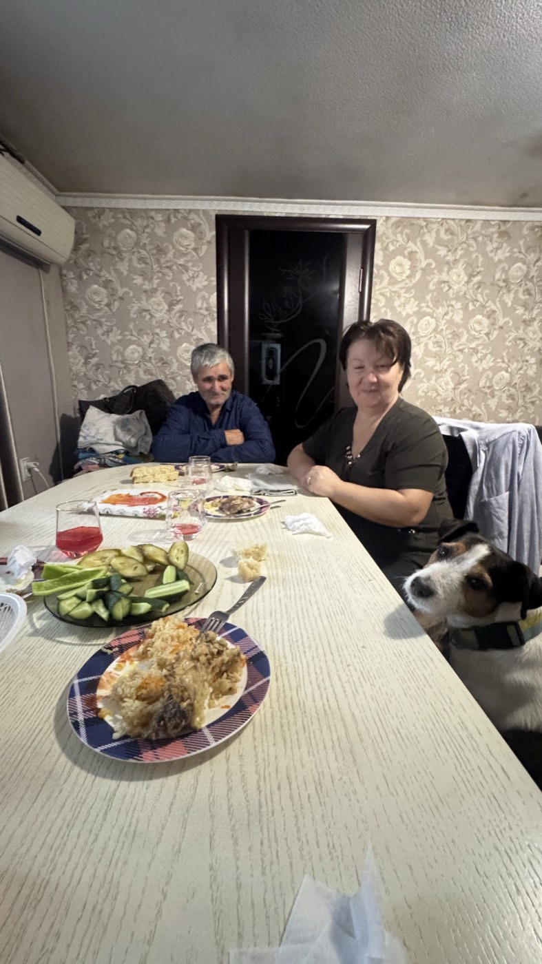 A family at their table in Kizlyar, with Jacko sitting up beside it