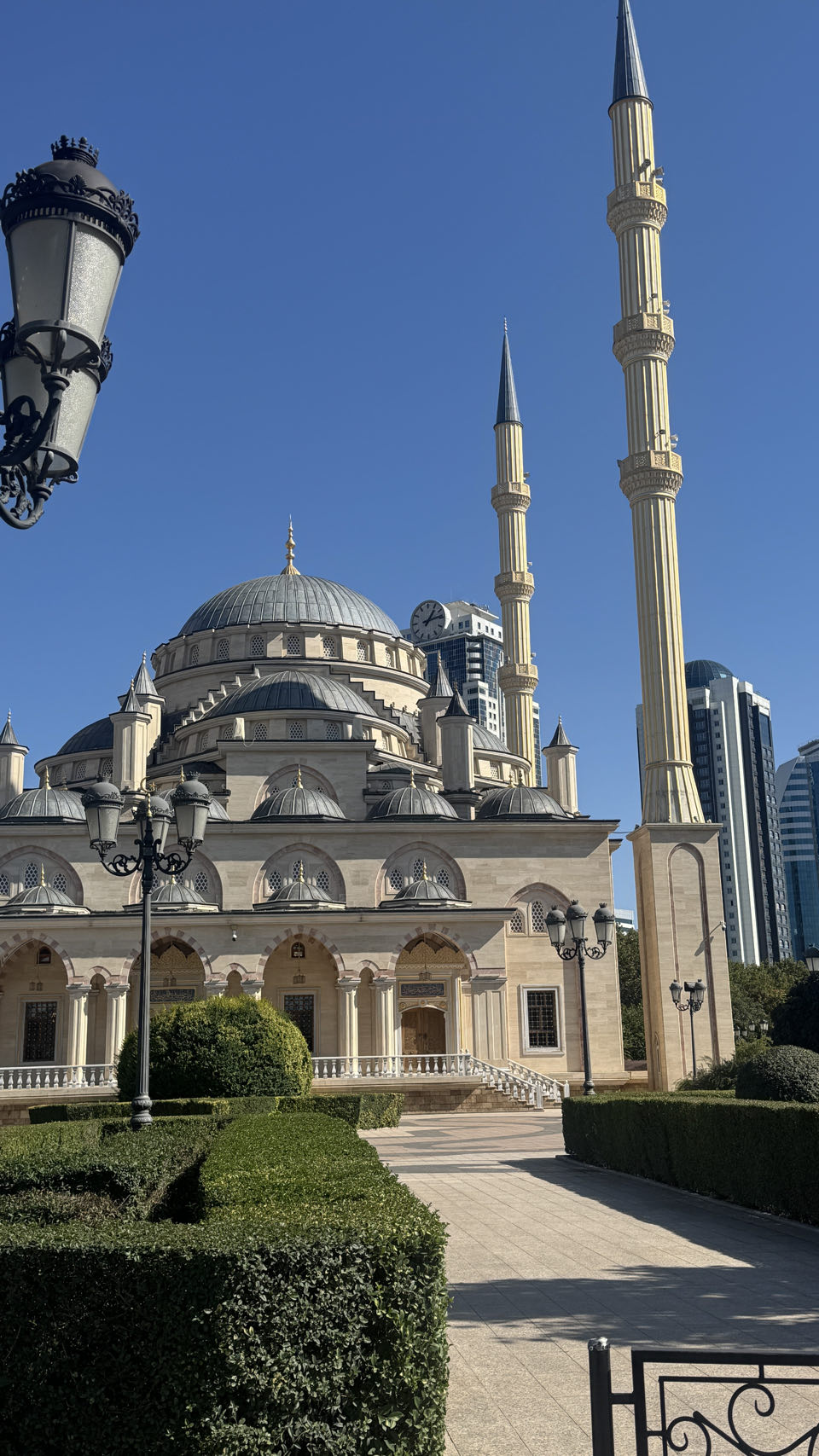 The Heart of Chechnya mosque in daylight, with a glass tower rising behind it
