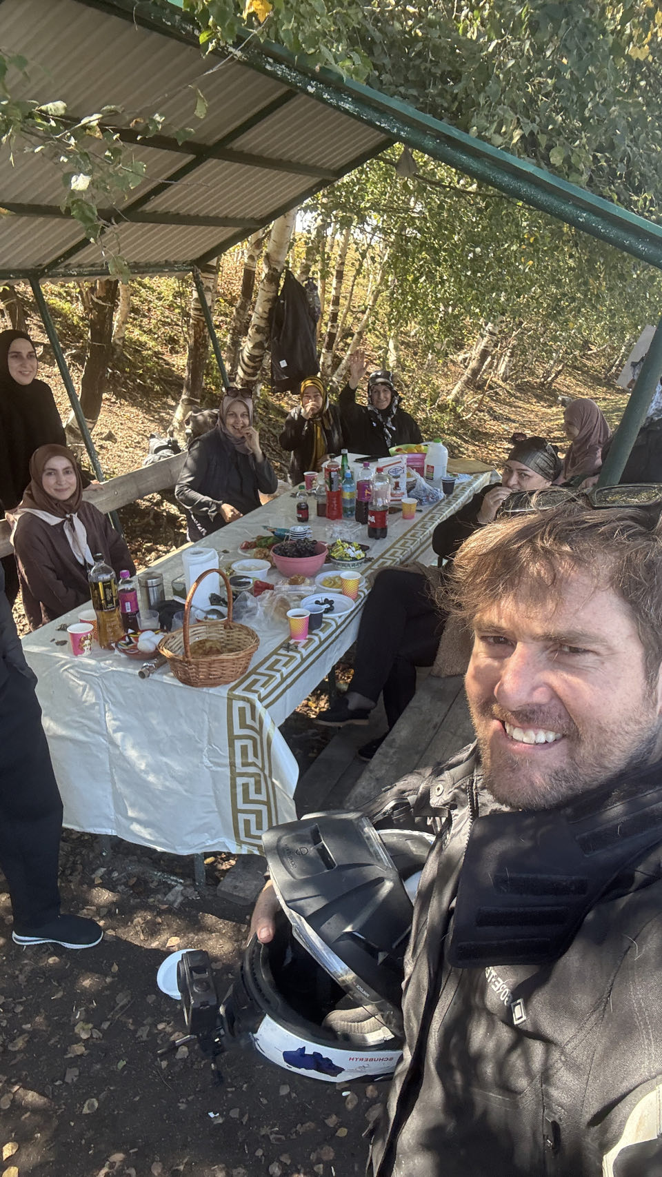 Rodrigo at the family table under a canopy above the canyon, still in riding gear