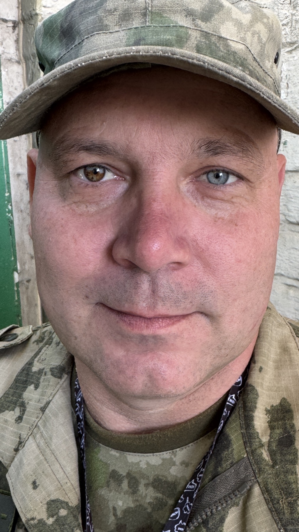 Close portrait of a Russian soldier in camouflage, one eye brown and the other blue