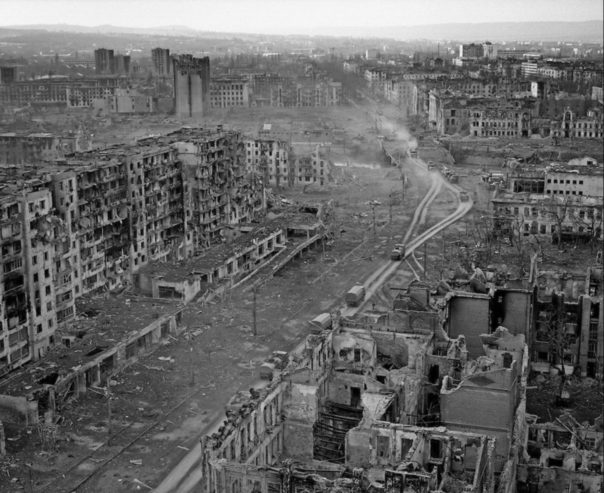Grozny in ruins after the war, whole blocks of flats burned out along an empty avenue