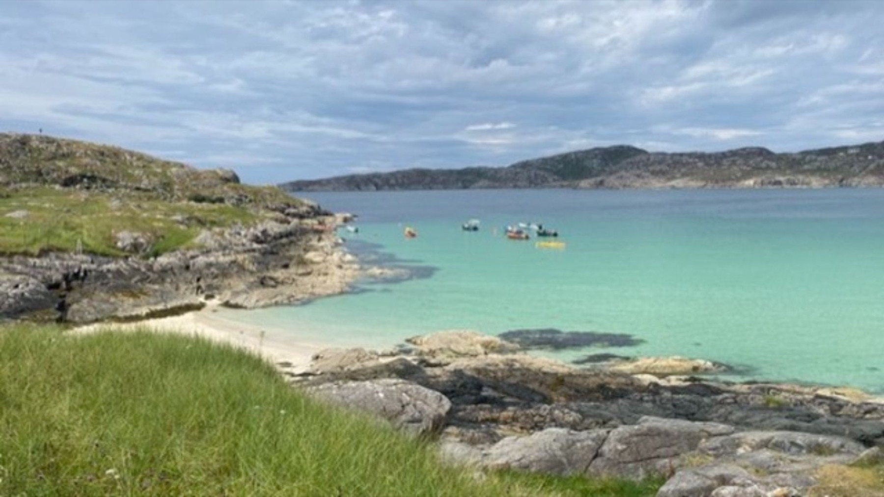 A turquoise bay with pale sand and rocks