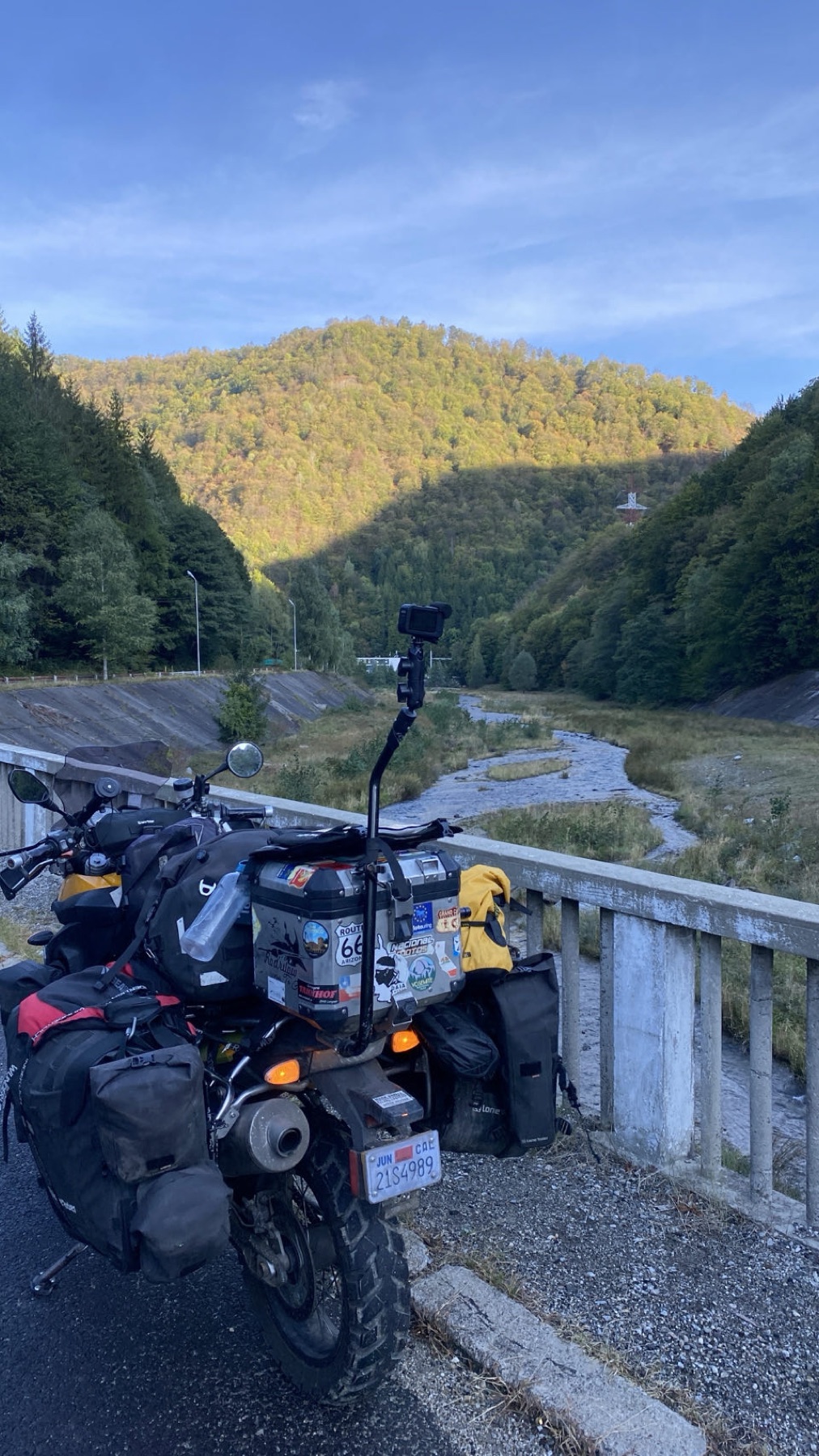 The loaded motorcycle on a bridge above a river valley