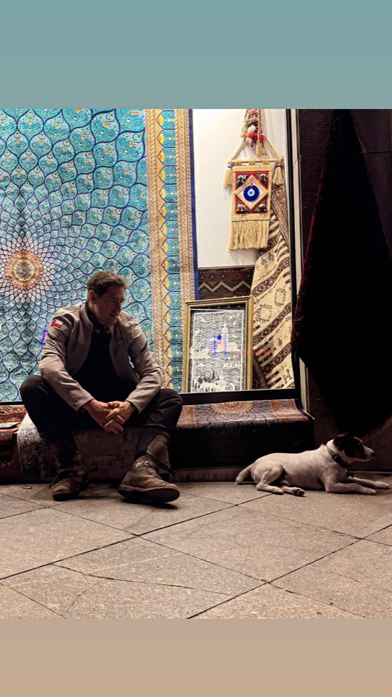 Rodrigo sitting in a tiled doorway with Jacko lying on the stone beside him