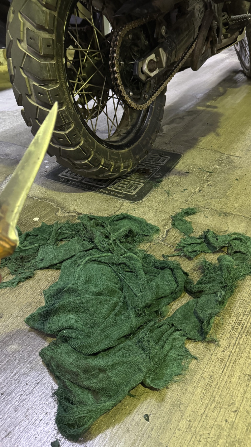 A towel tangled in the rear chain of the motorcycle