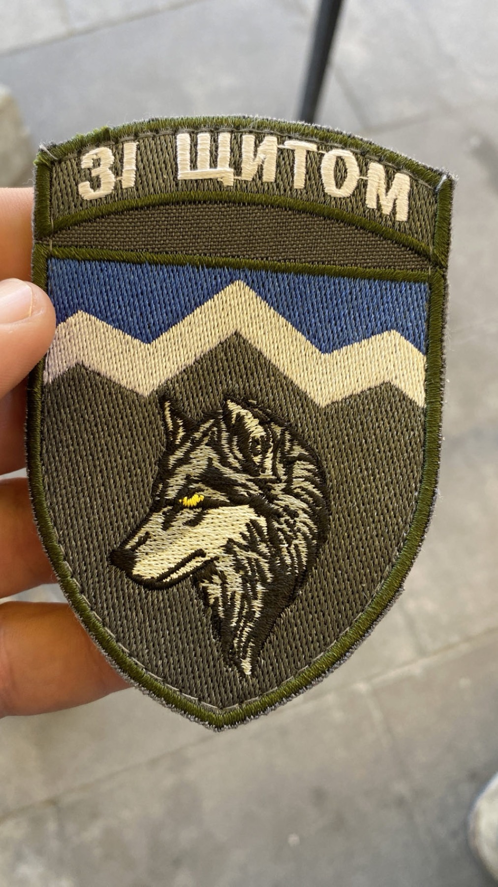 A Ukrainian military unit patch held in a hand