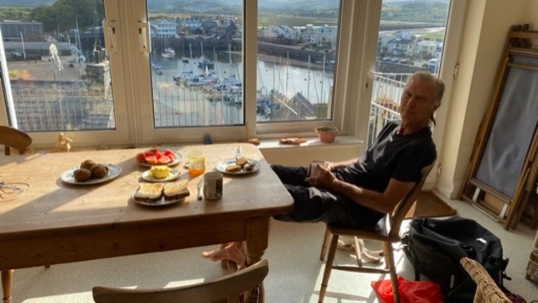 Breakfast laid out at a table by a window, with the host sitting across